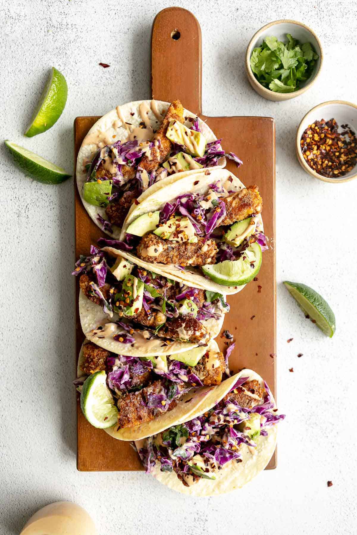 gluten free baked fish tacos on a wood board