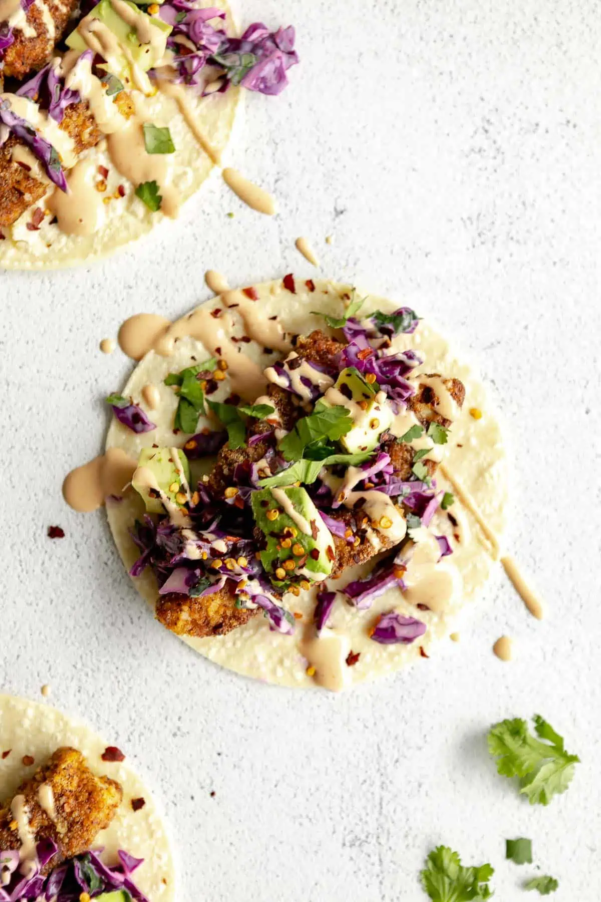 gluten free baked cod fish tacos with spicy dressing on top
