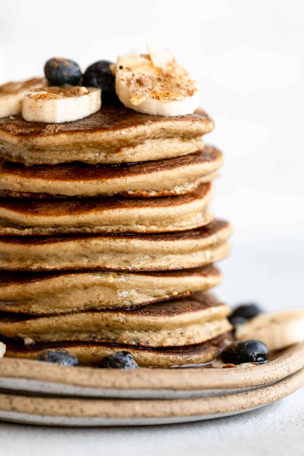 stack of pancakes on a plate with banana and blueberries