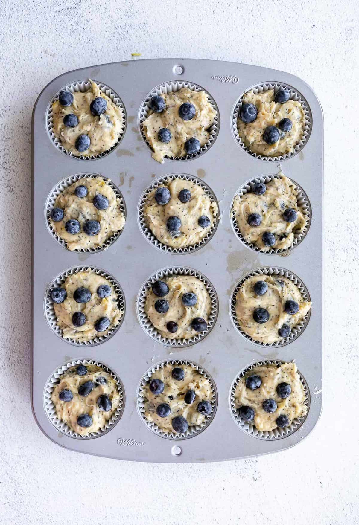 gluten free blueberry muffin batter in a muffin tray before baking
