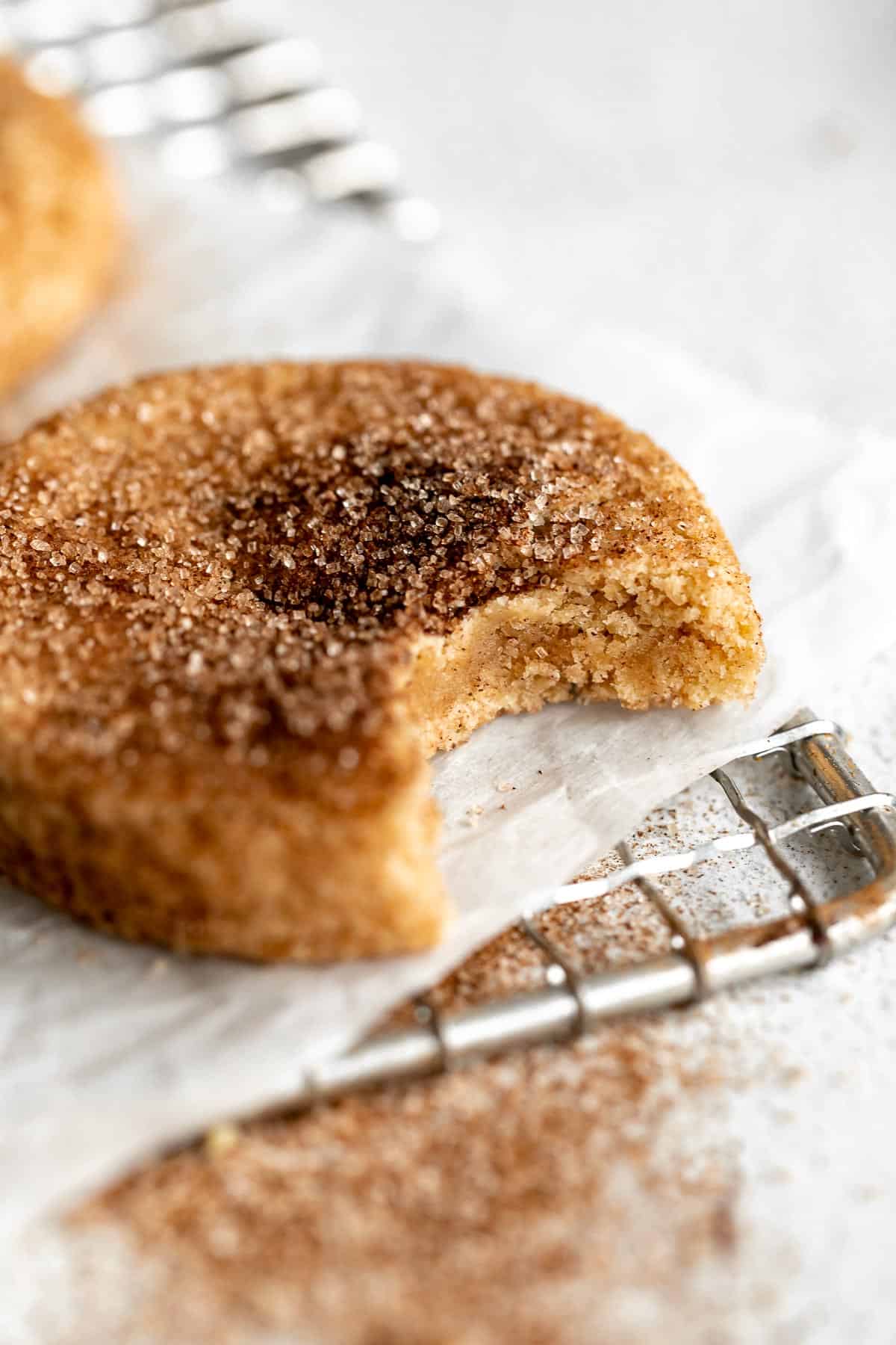 one bite taken out of the gluten free snickerdoodle to show the chewy texture