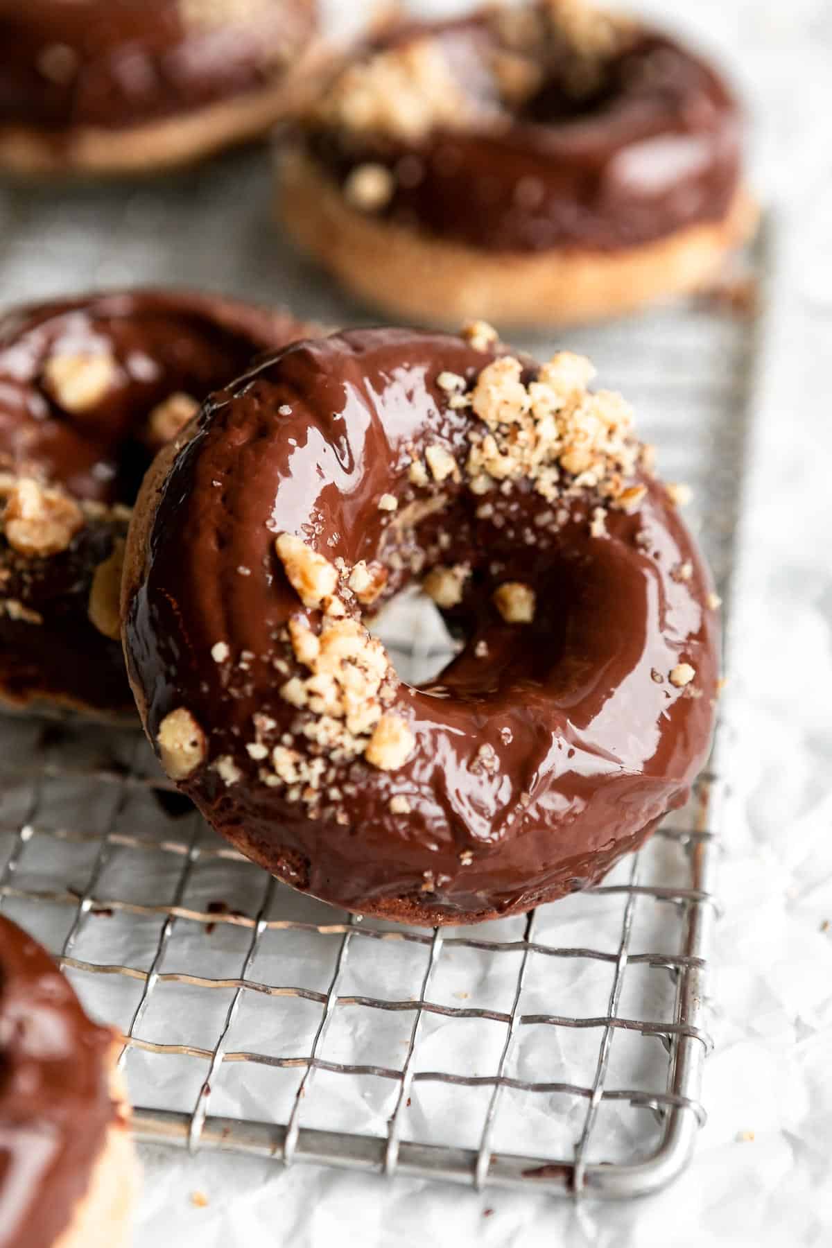 gluten free healthy donuts with crushed walnuts on top on a wire rack
