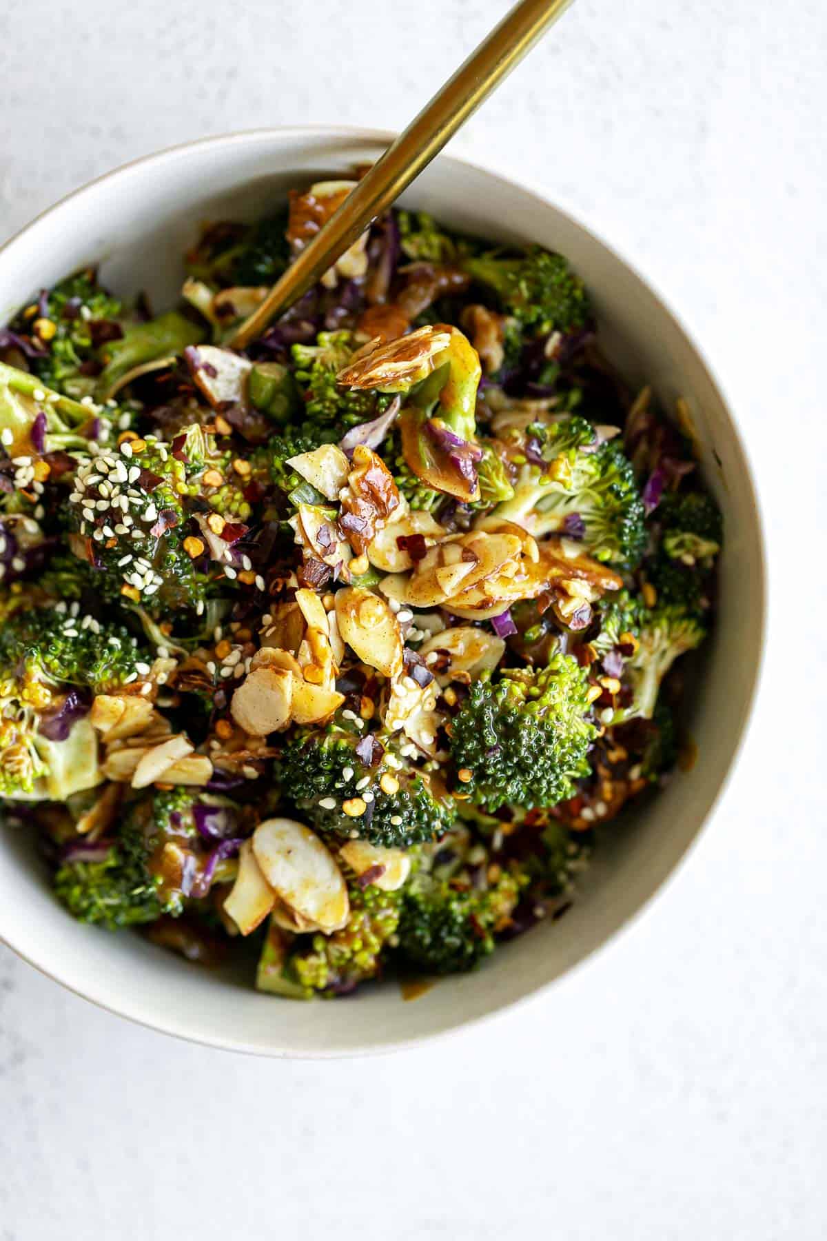 vegan broccoli salad in a bowl with sliced almonds on top