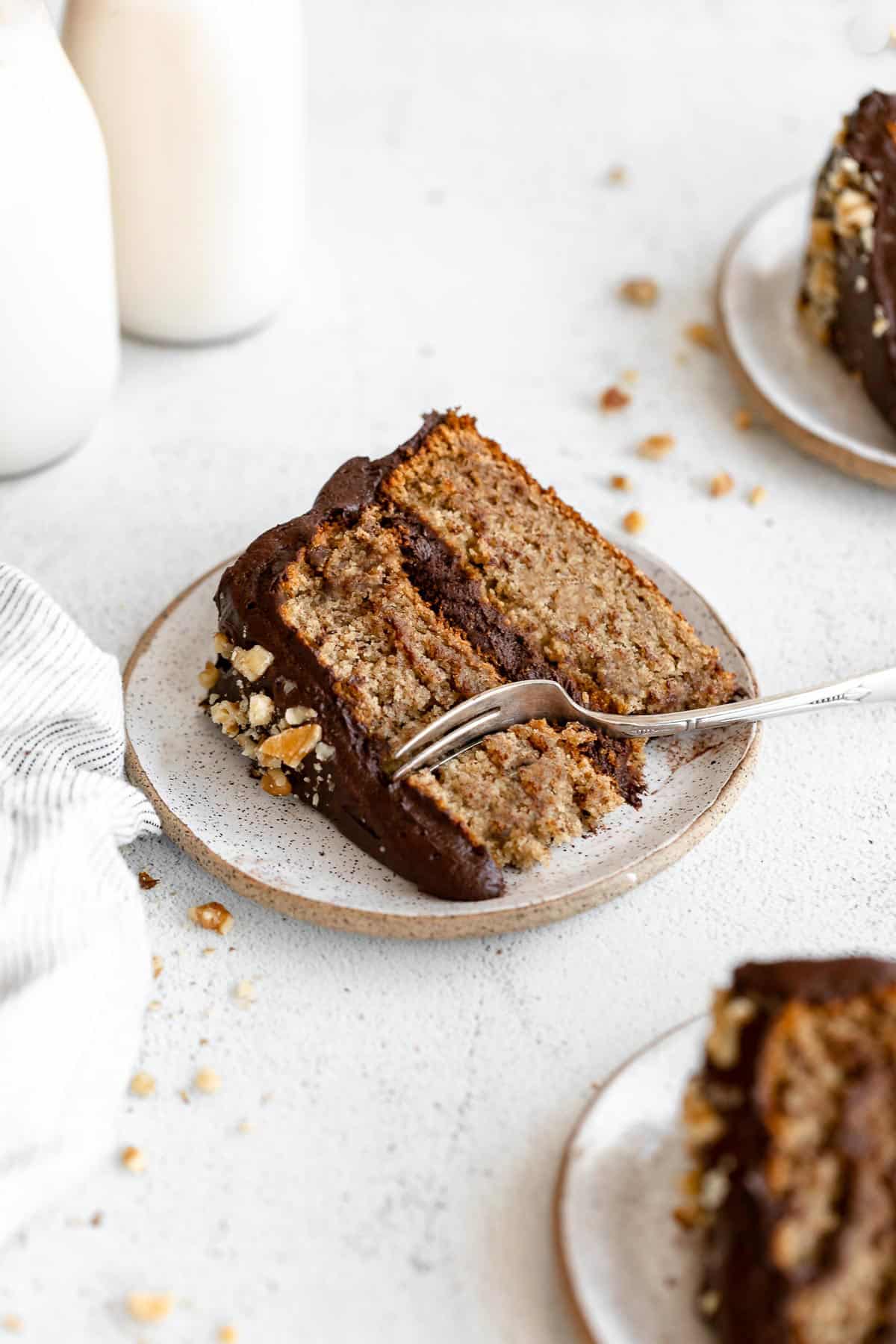slice of the vegan banana cake on a plate with a fork on the side