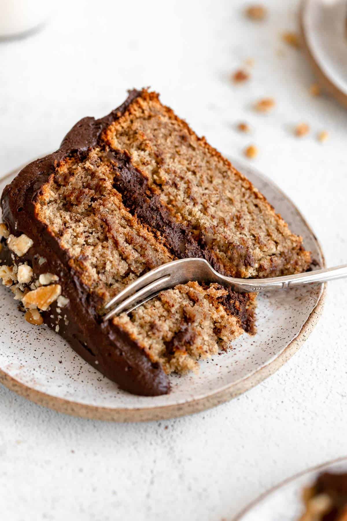 Up close image of a slice of the vegan banana cake on a plate with a fork