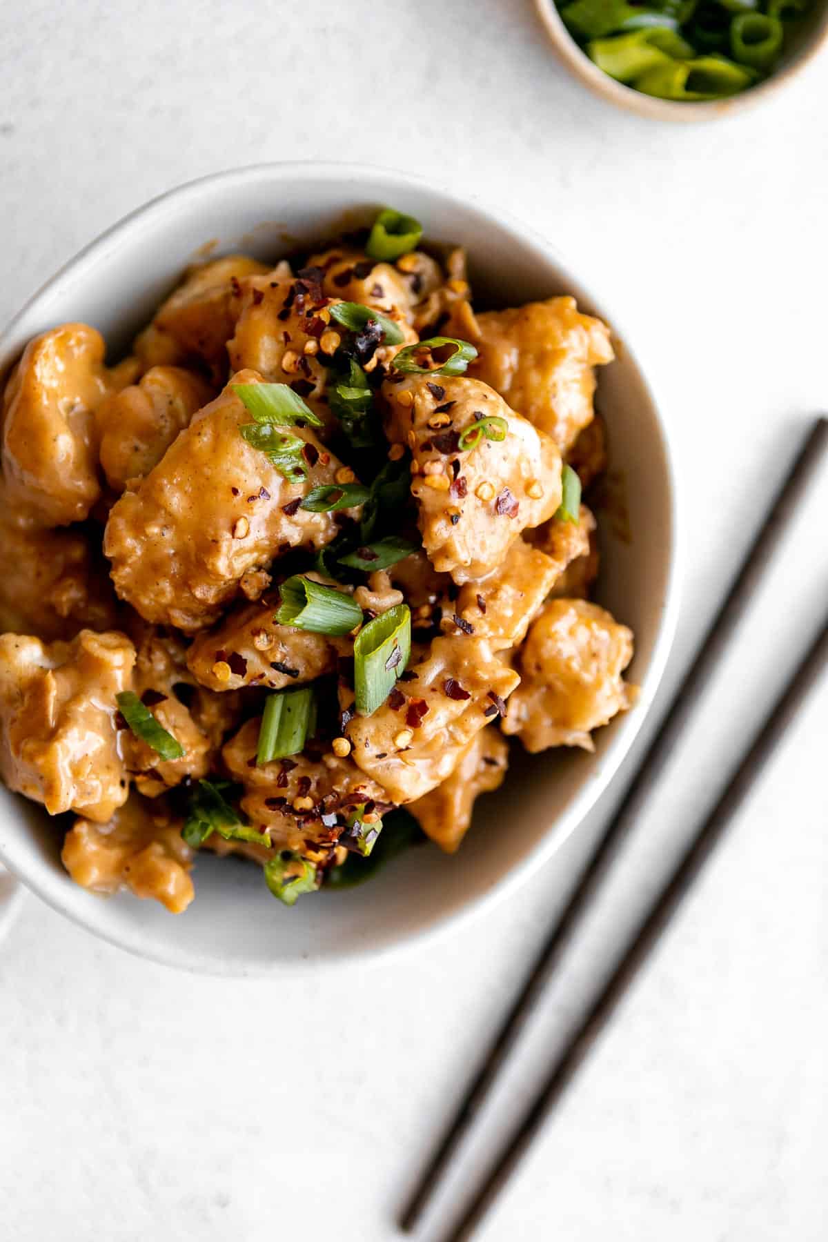 vegan cauliflower wings in a bowl with chopsticks on the side