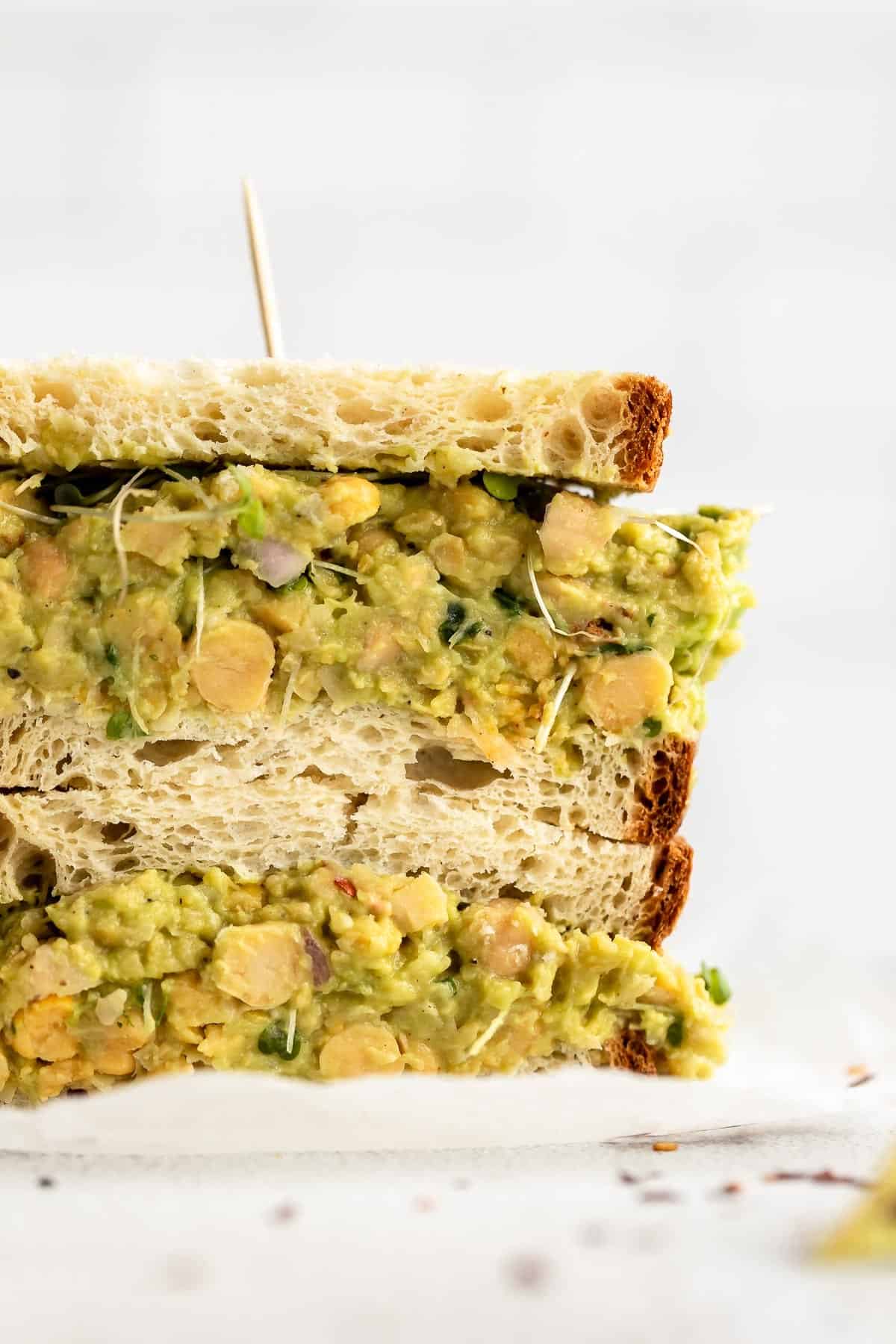 mashed chickpea avocado salad in a sandwich with lemon