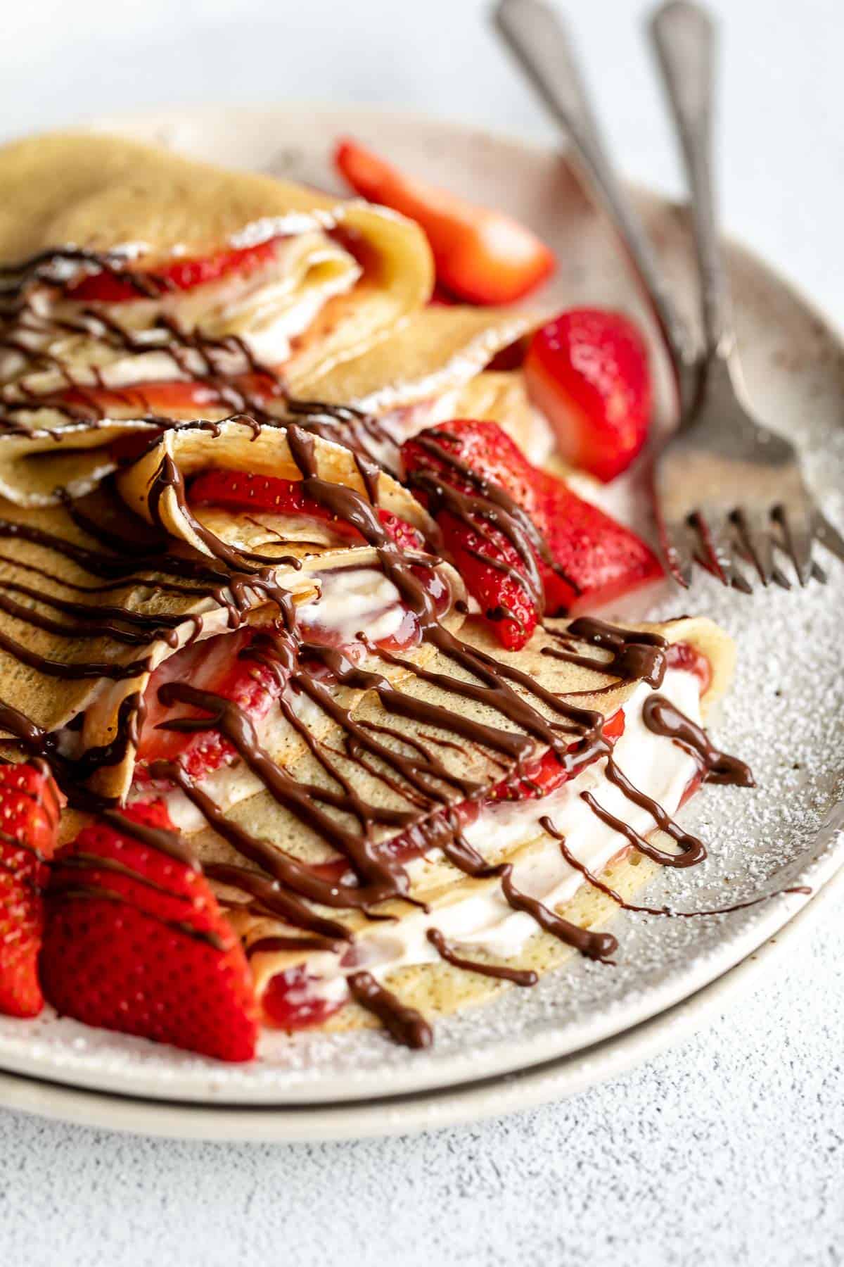 up close image of the crepes on a plate with berries and chocolate