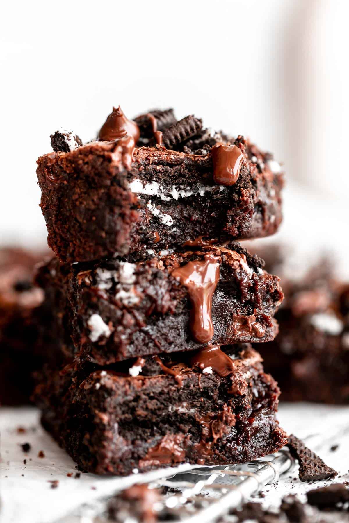 three gluten free brownies stacked on each other with melted chocolate
