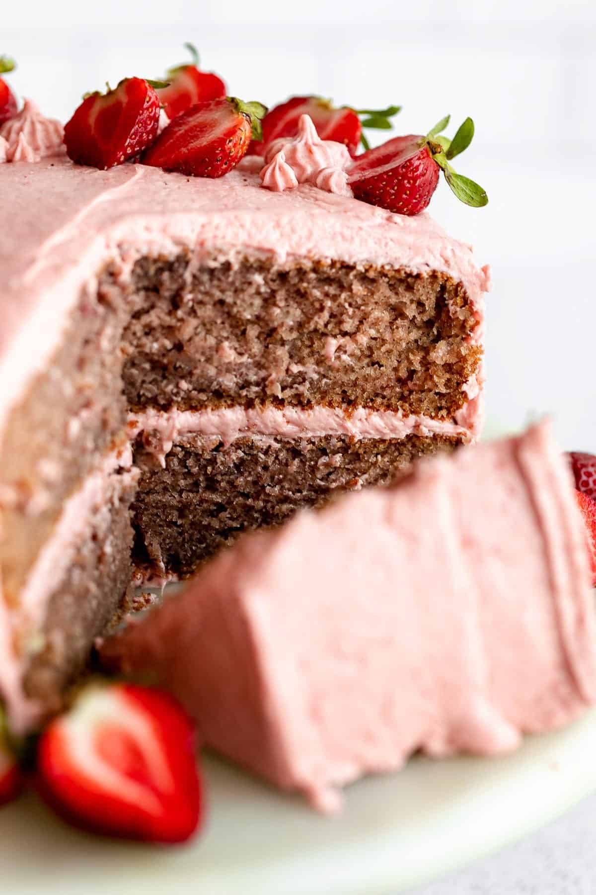 gluten free strawberry cake on a cake stand with fresh strawberries