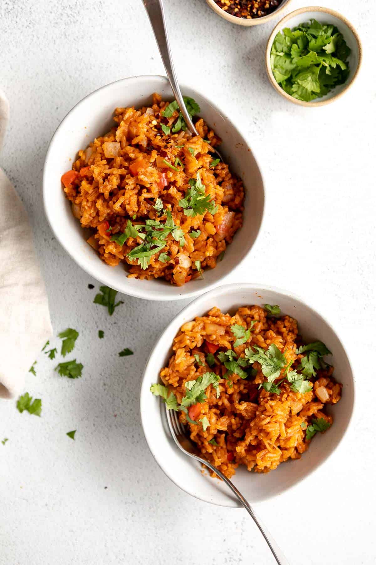 two bowls of the vegan mexican rice with forks on the side