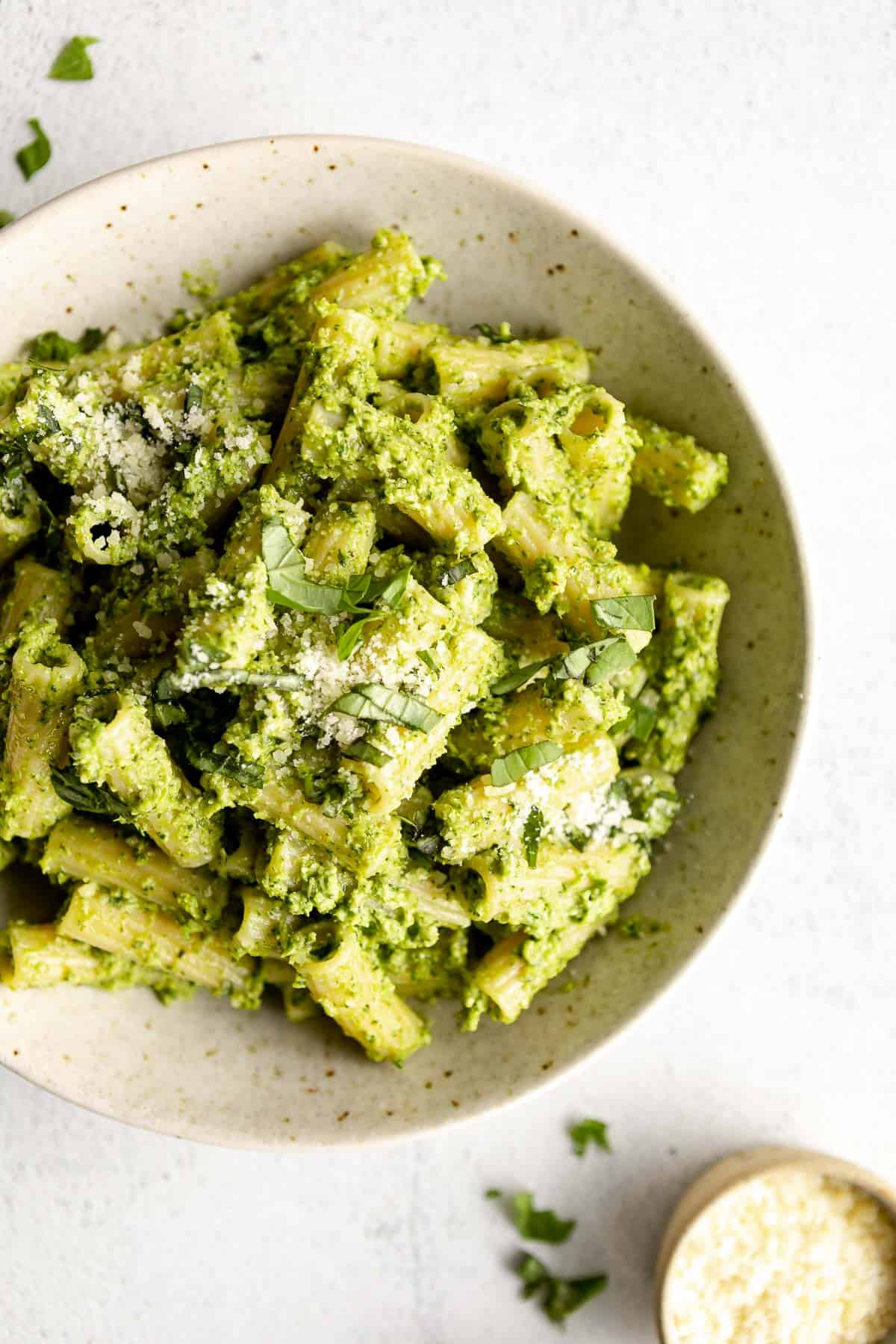 broccoli pesto pasta in a bowl with parmesan cheese on top