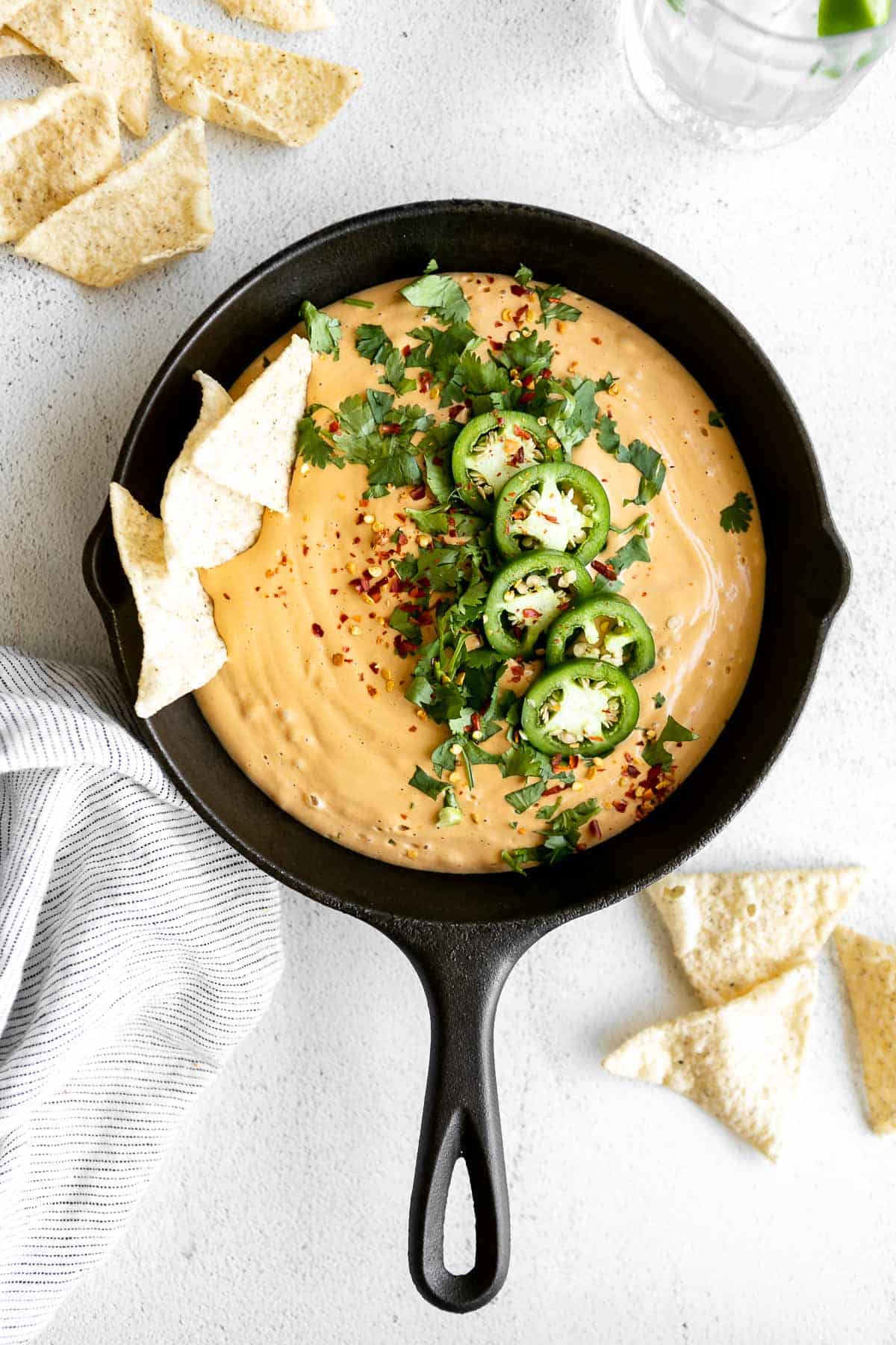 vegan cashew queso with jalapenos on top and chips on the side