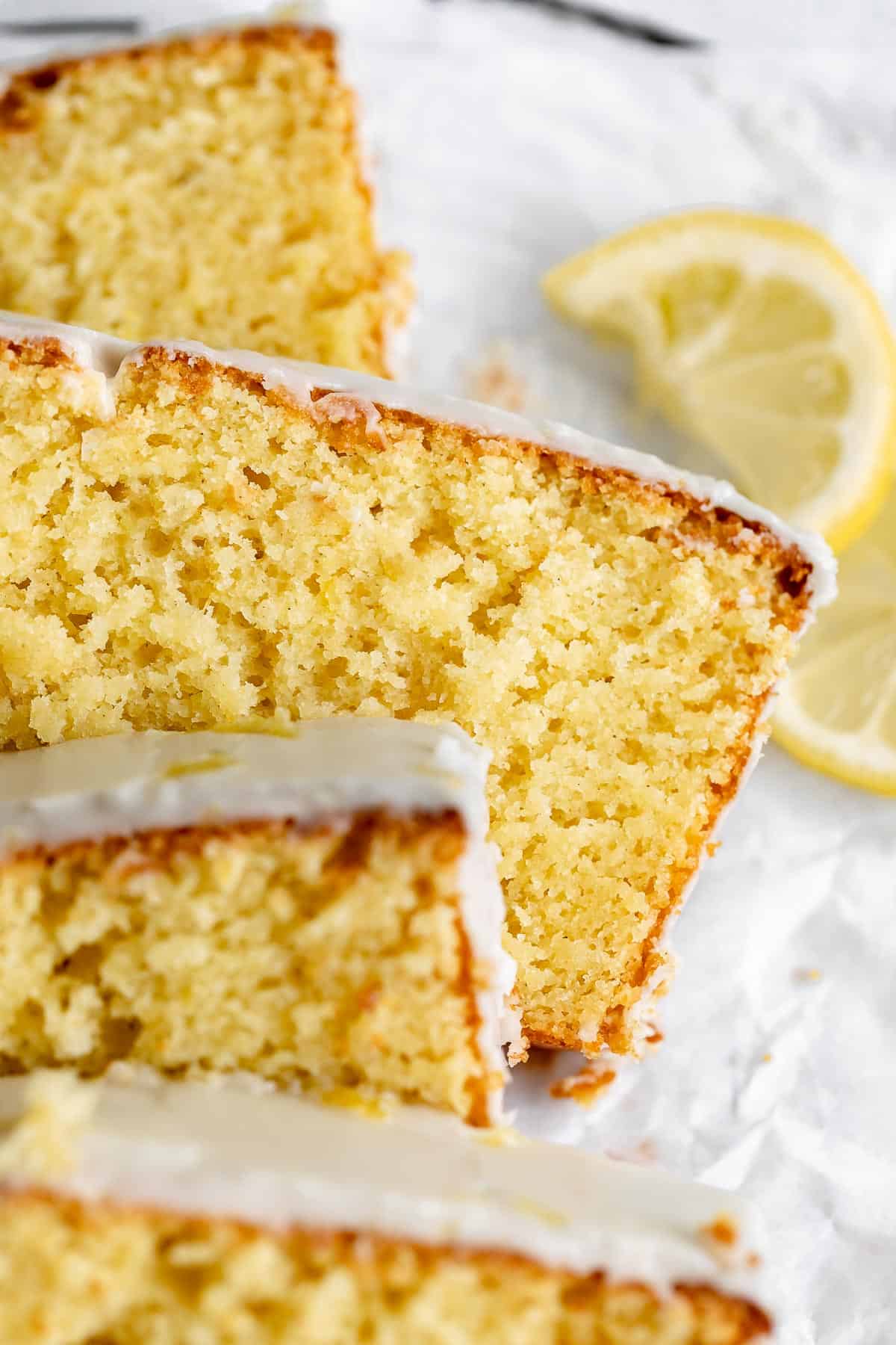 gluten free lemon drizzle cake sliced with a glaze on top