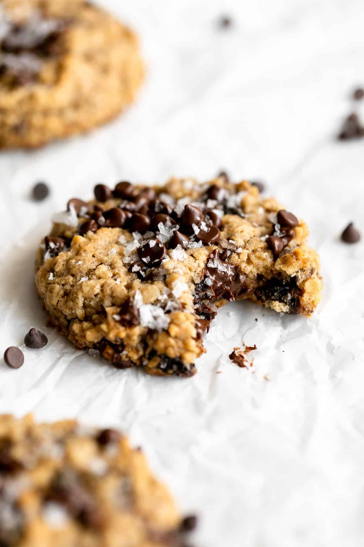 vegan oatmeal raisin cookies with chocolate chips and a bite taken out