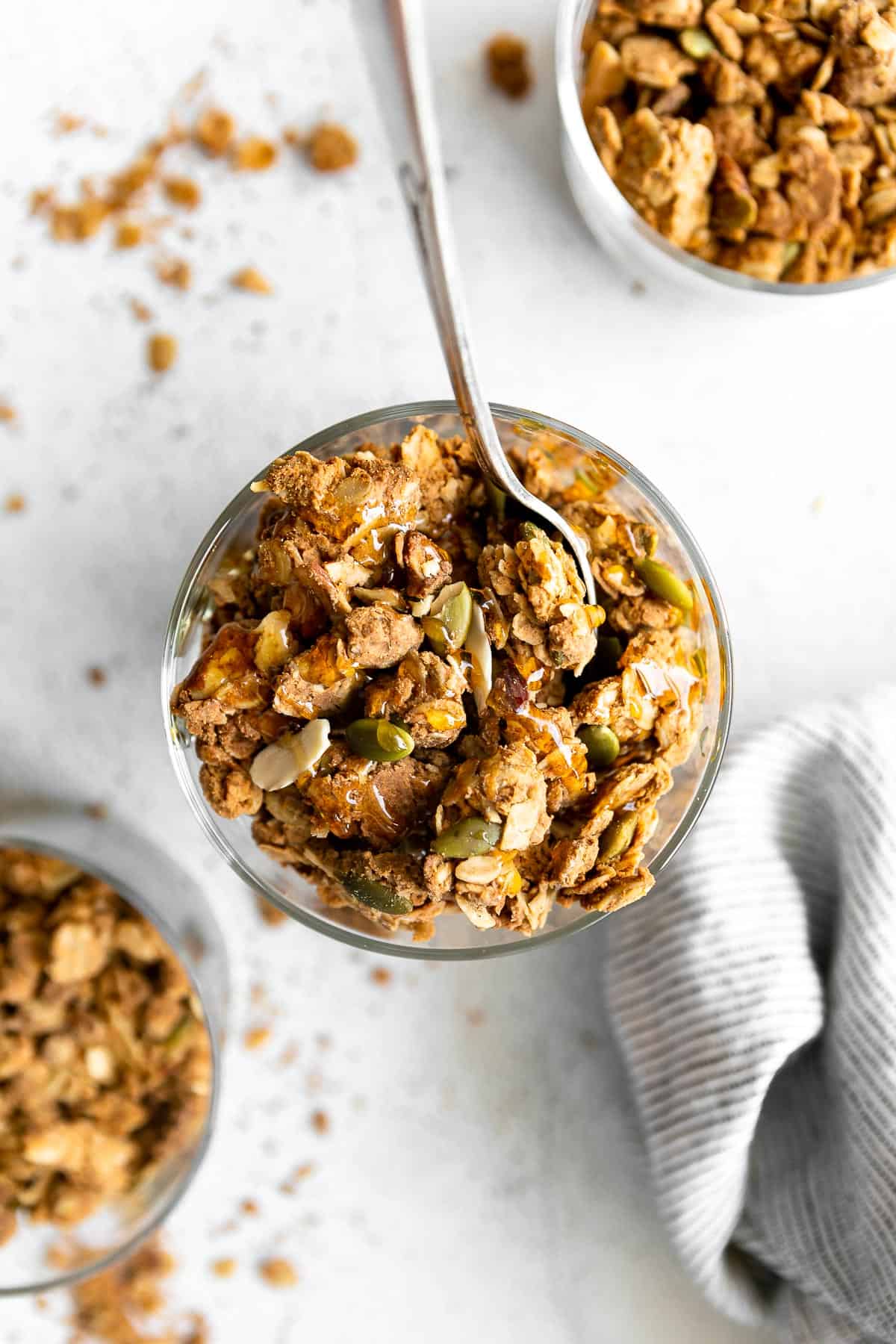 peanut butter protein granola in a glass bowl with a spoon on the side