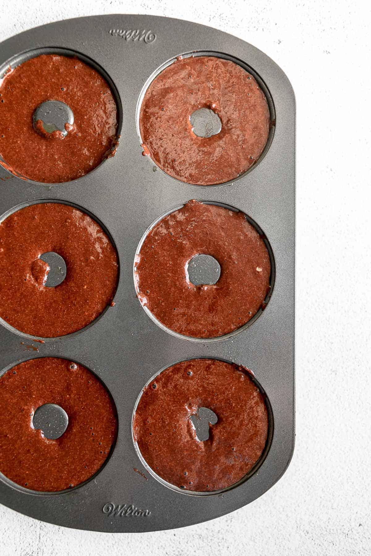 chocolate batter in a donut pan before baking