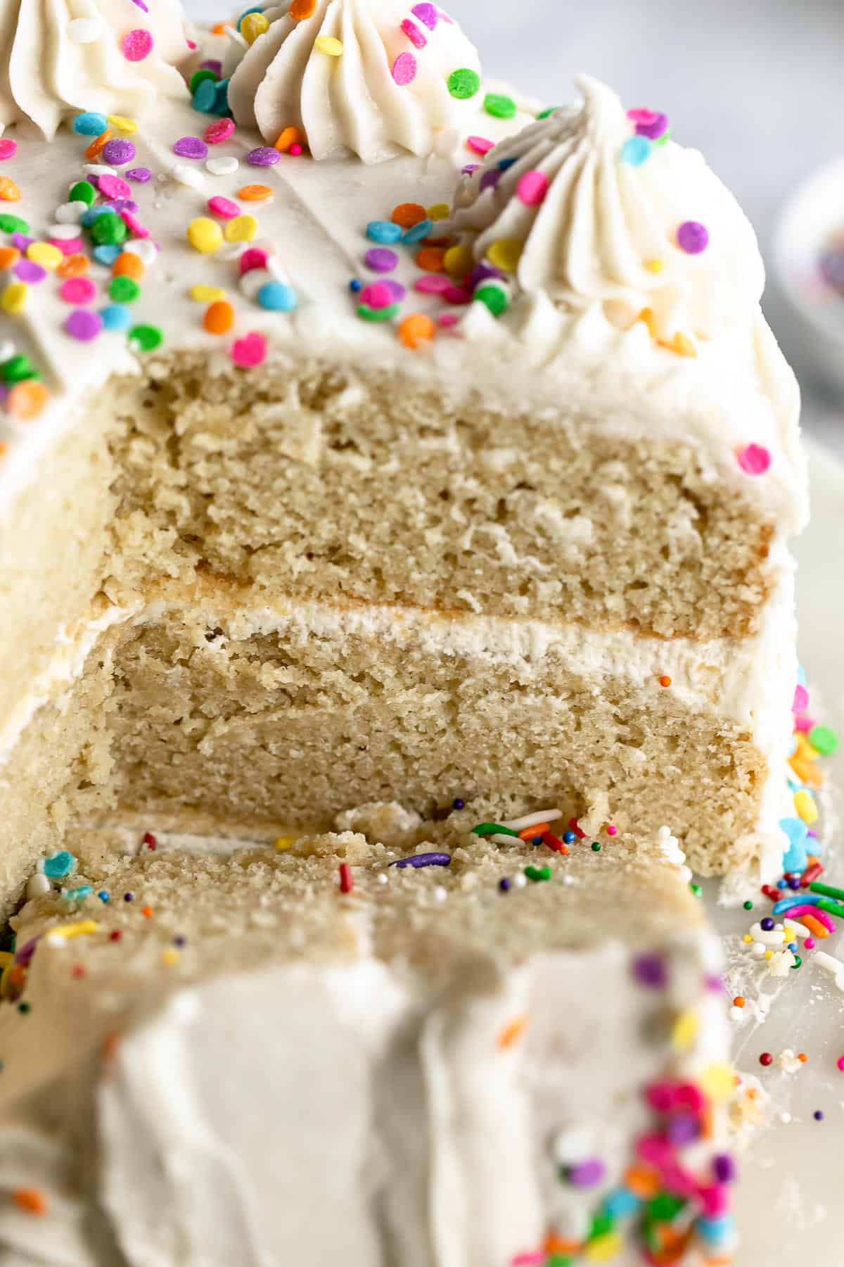 gluten free vanilla cake on a cake stand with sprinkles