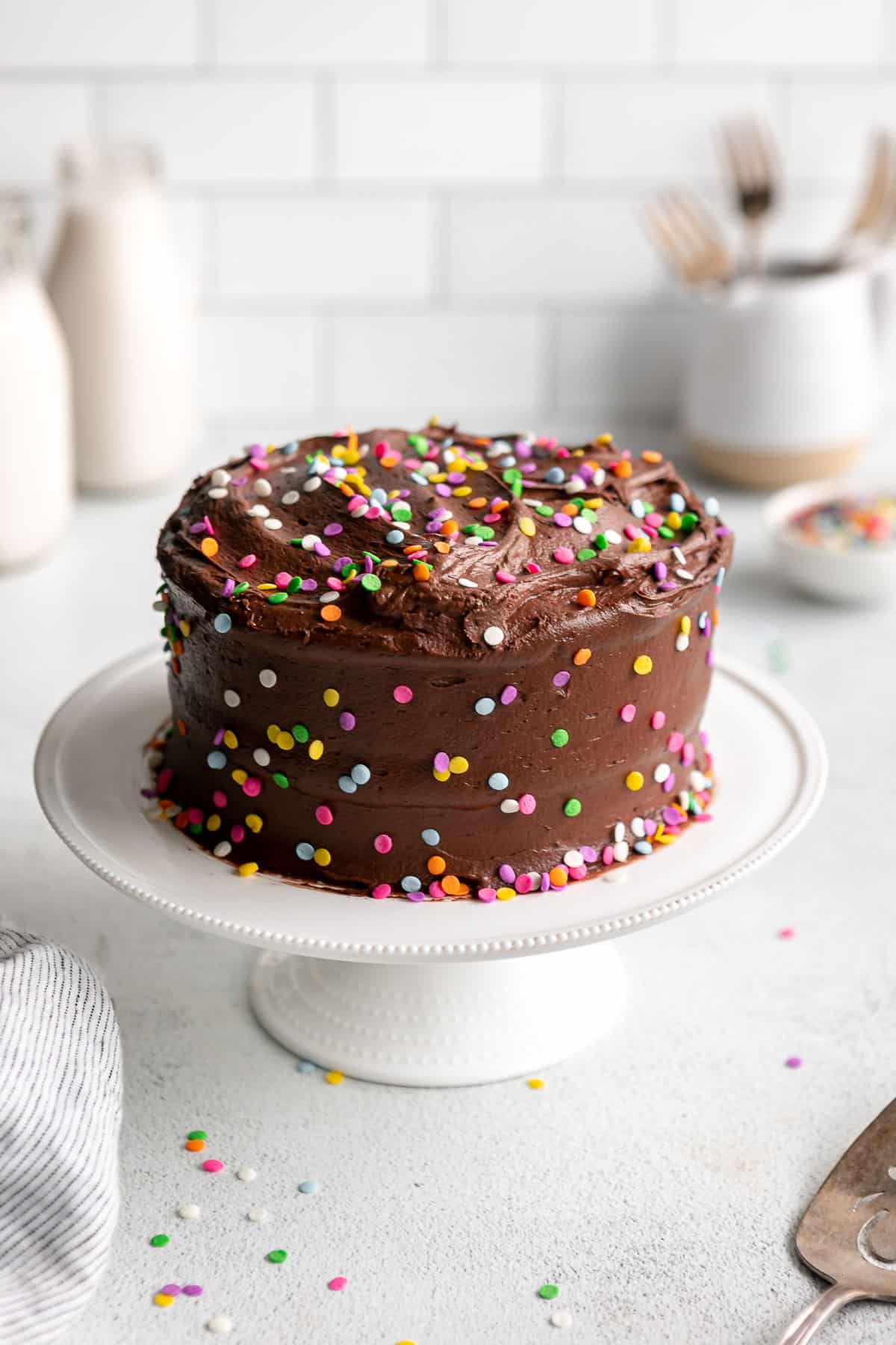 mini chocolate cake with rainbow sprinkles on a small cake stand