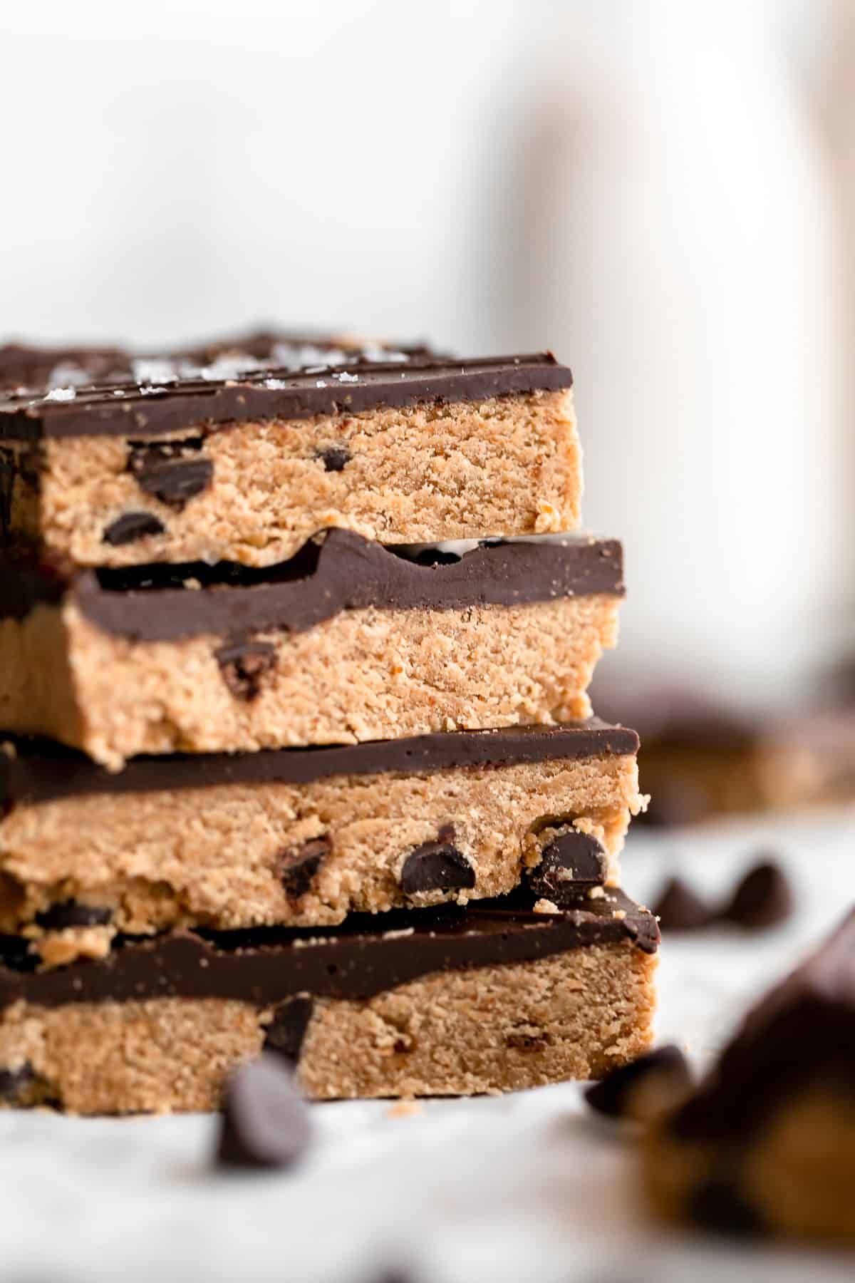 four vegan protein bars stacked on each other with chocolate chips