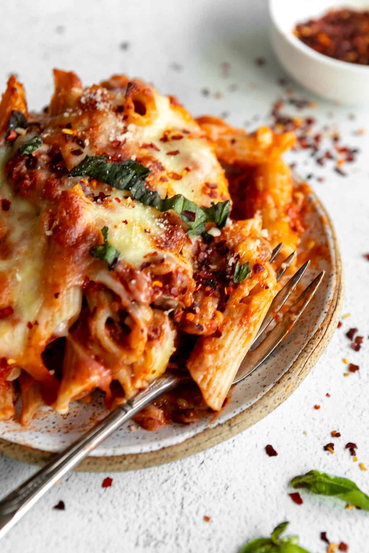 vegan baked penne on a plate with a fork on the side