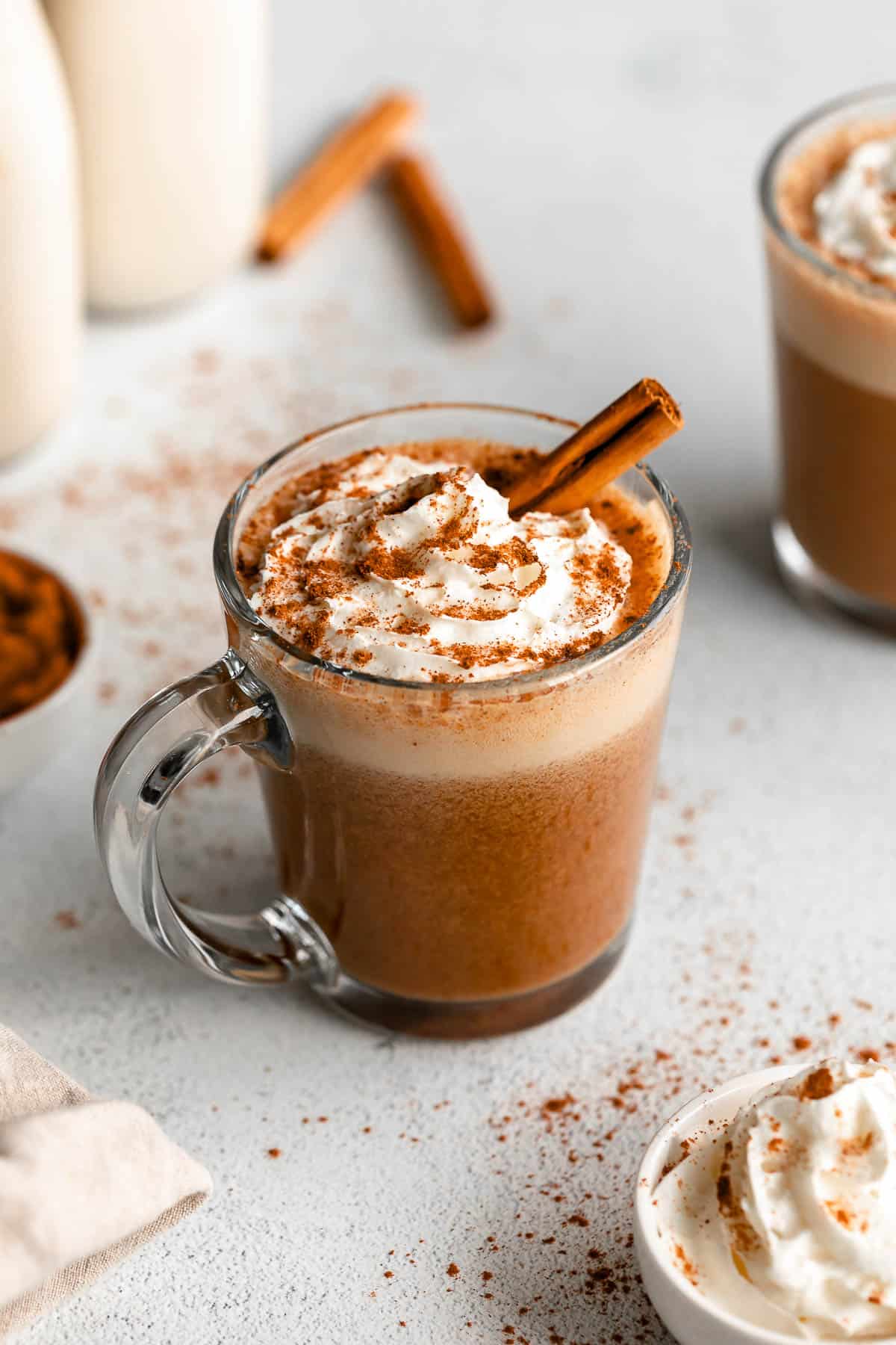 vegan pumpkin spice latte in a glass mug with whipped cream