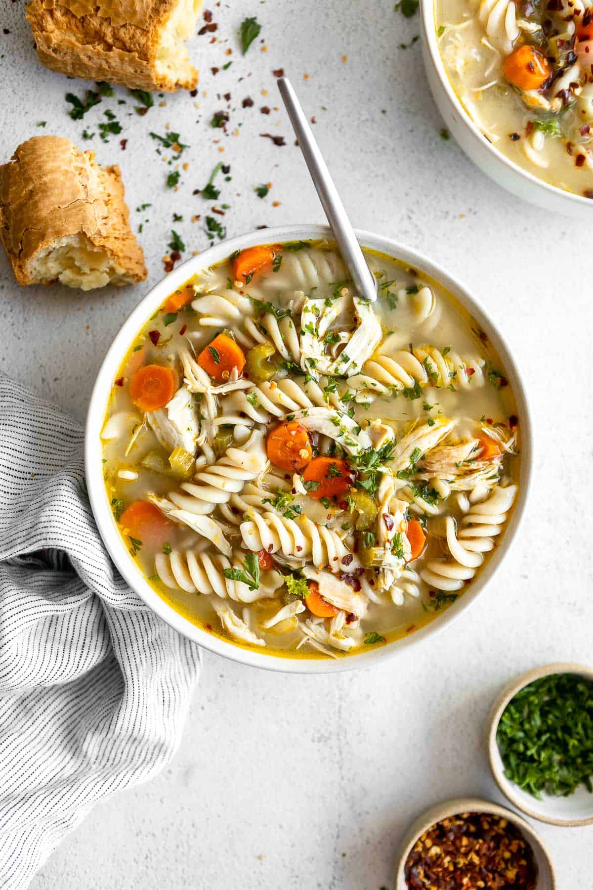 gluten free chicken noodle soup in a bowl with bread