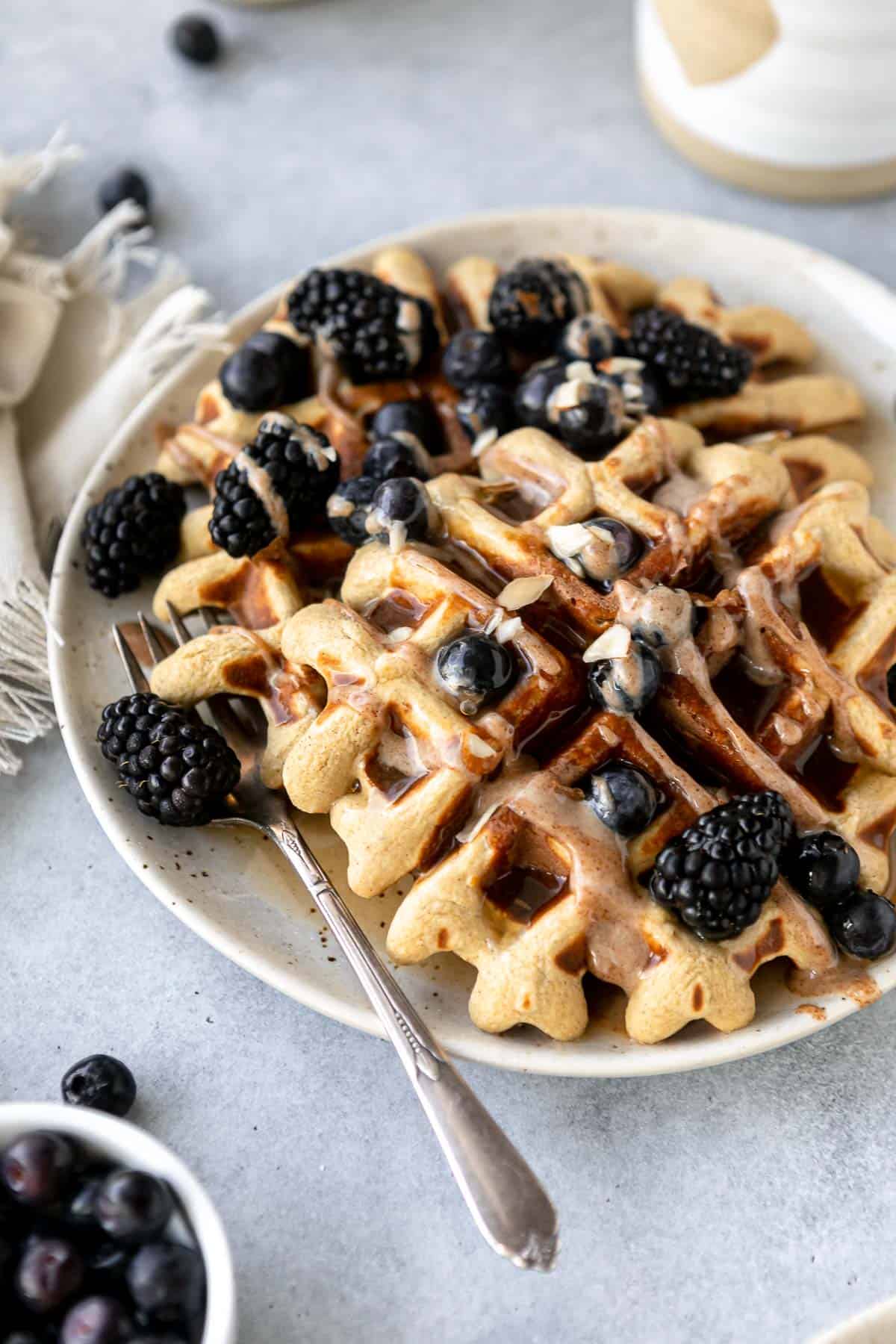 protein waffles on plate with berries and maple syrup