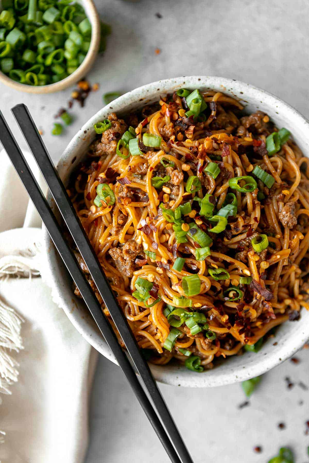 korean gochujang noodles with beef and scallions on top