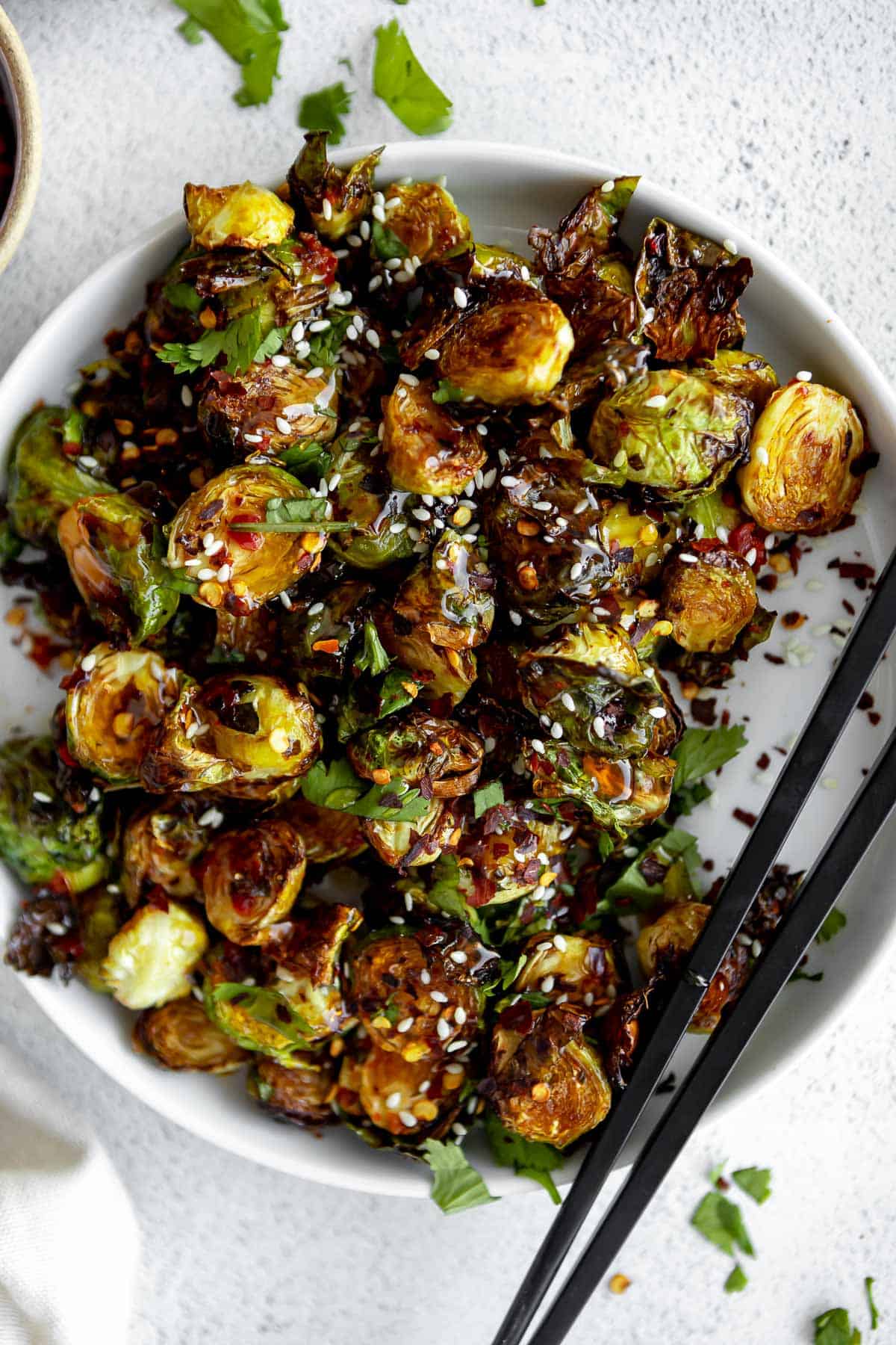 air fryer brussels sprouts on a plate with chopsticks
