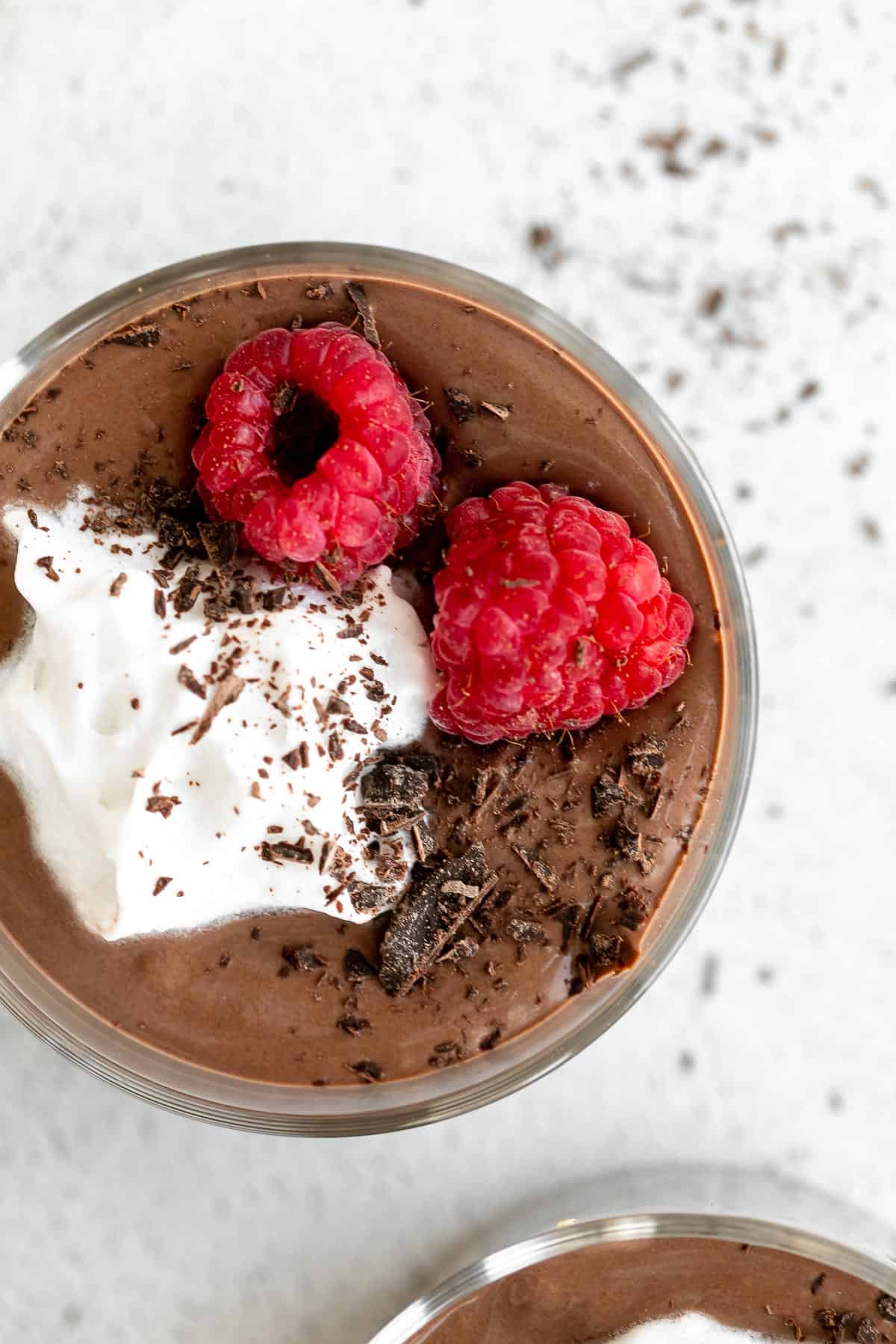 vegan chocolate protein pudding in a cup with whipped cream