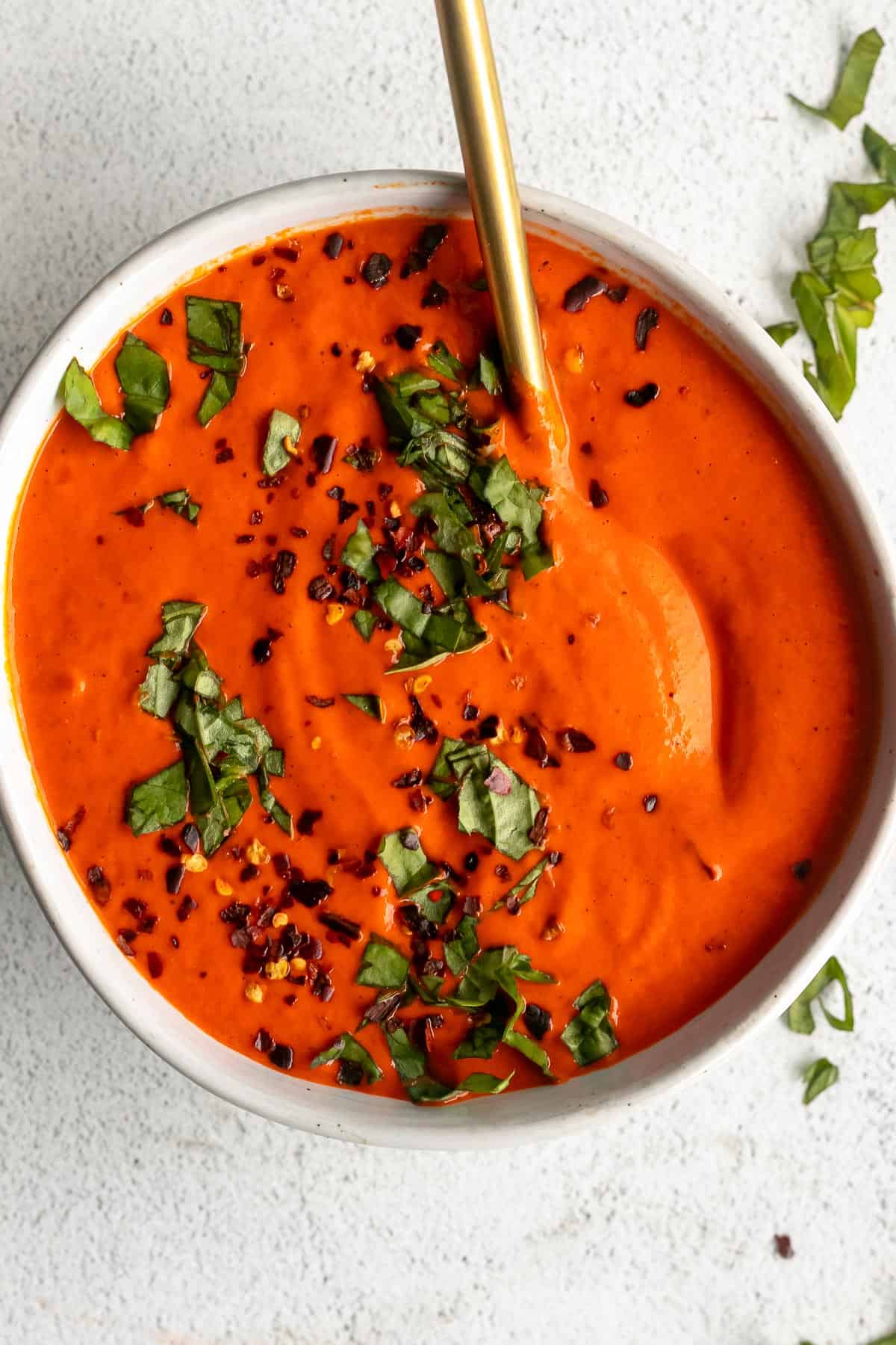 vegan roasted red pepper sauce in a bowl with basil