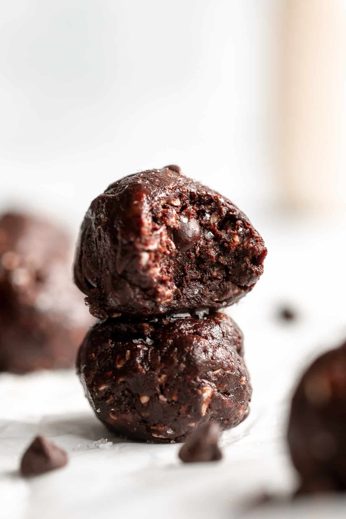 two chocolate protein bliss balls stacked on each other
