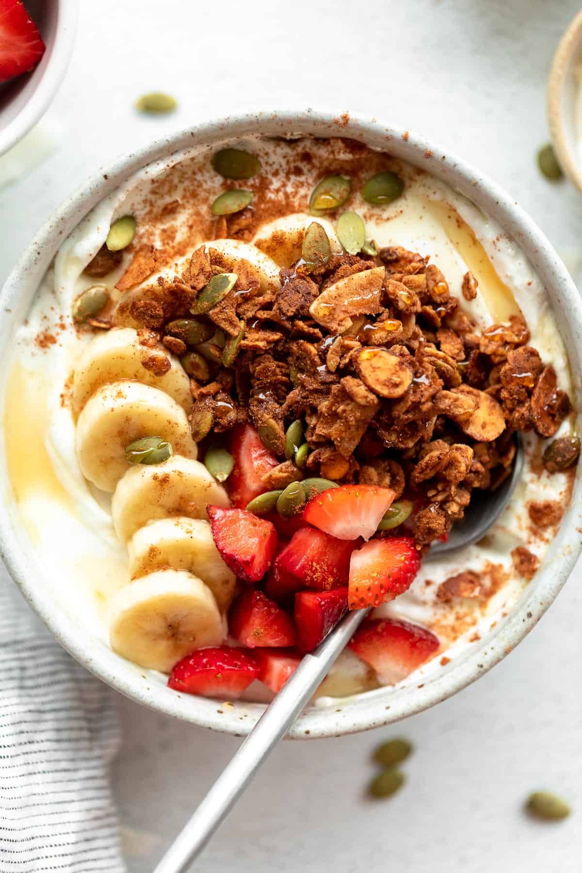 gluten free granola with yogurt, berries and banana in a bowl