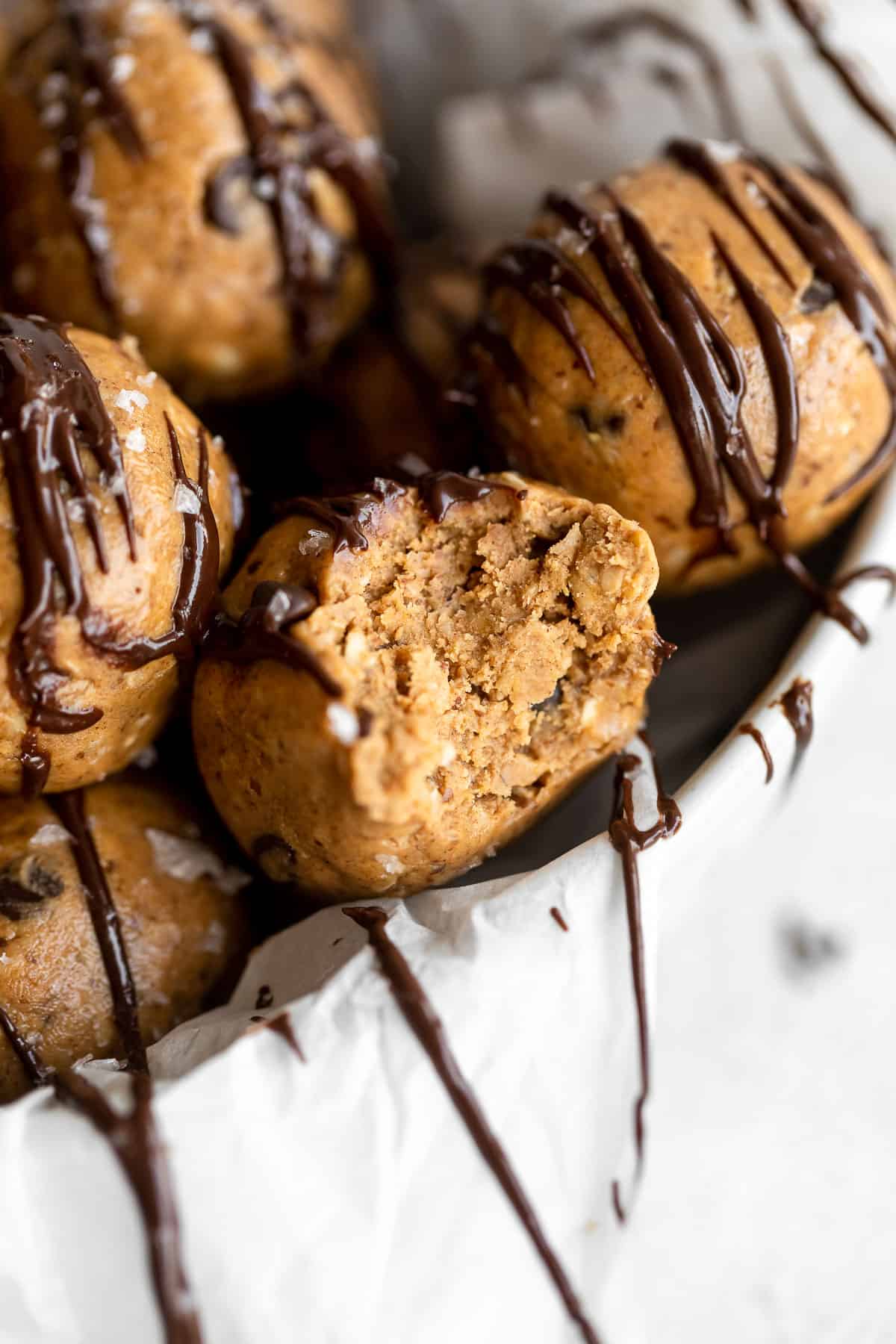 protein balls in a bowl with melted chocolate