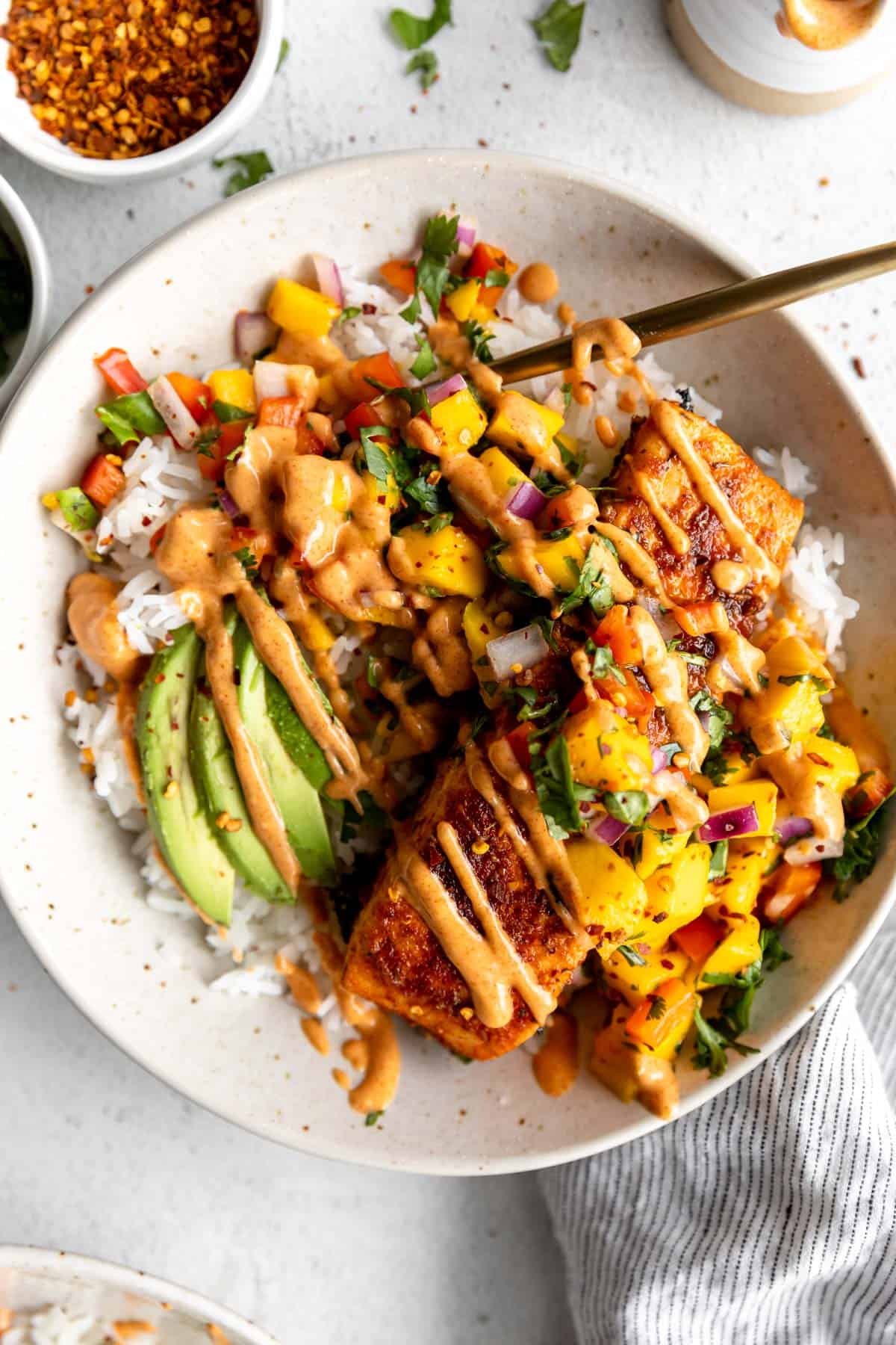 salmon bowls with avocado and sauce drizzled on top