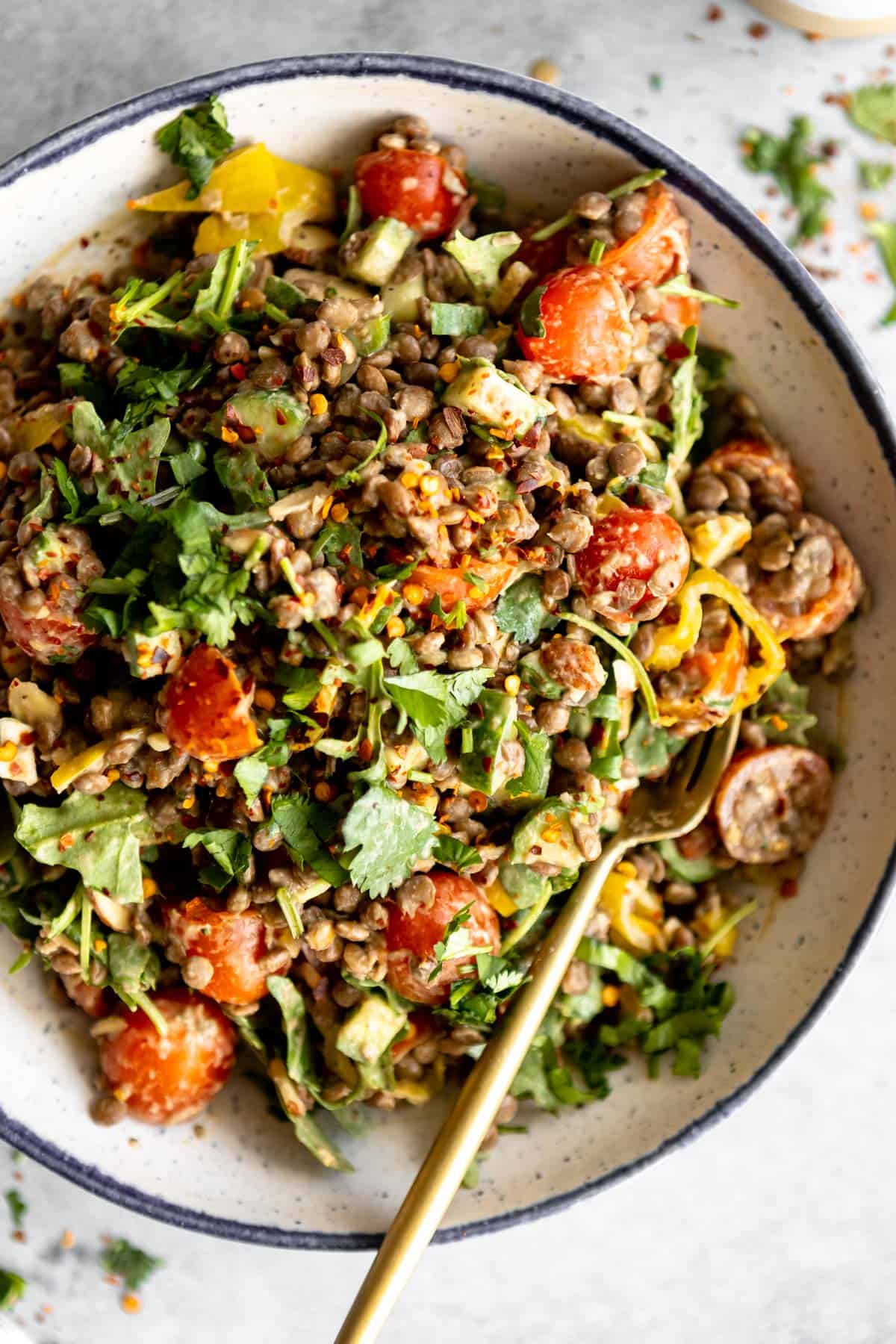 mediterranean lentil salad in a bowl with a fork on the side