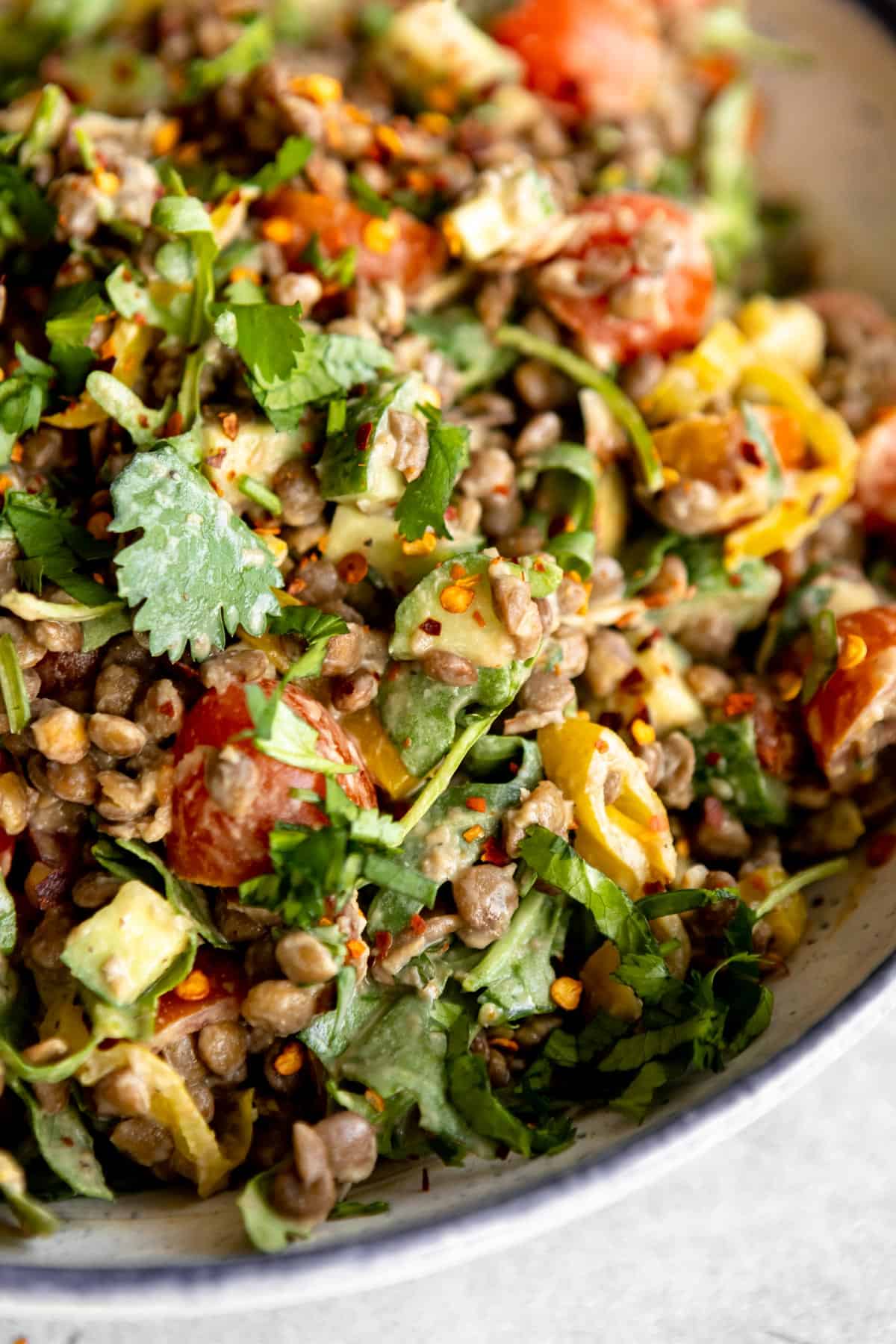 lentil salad with vegan tahini dressing tossed in a bowl