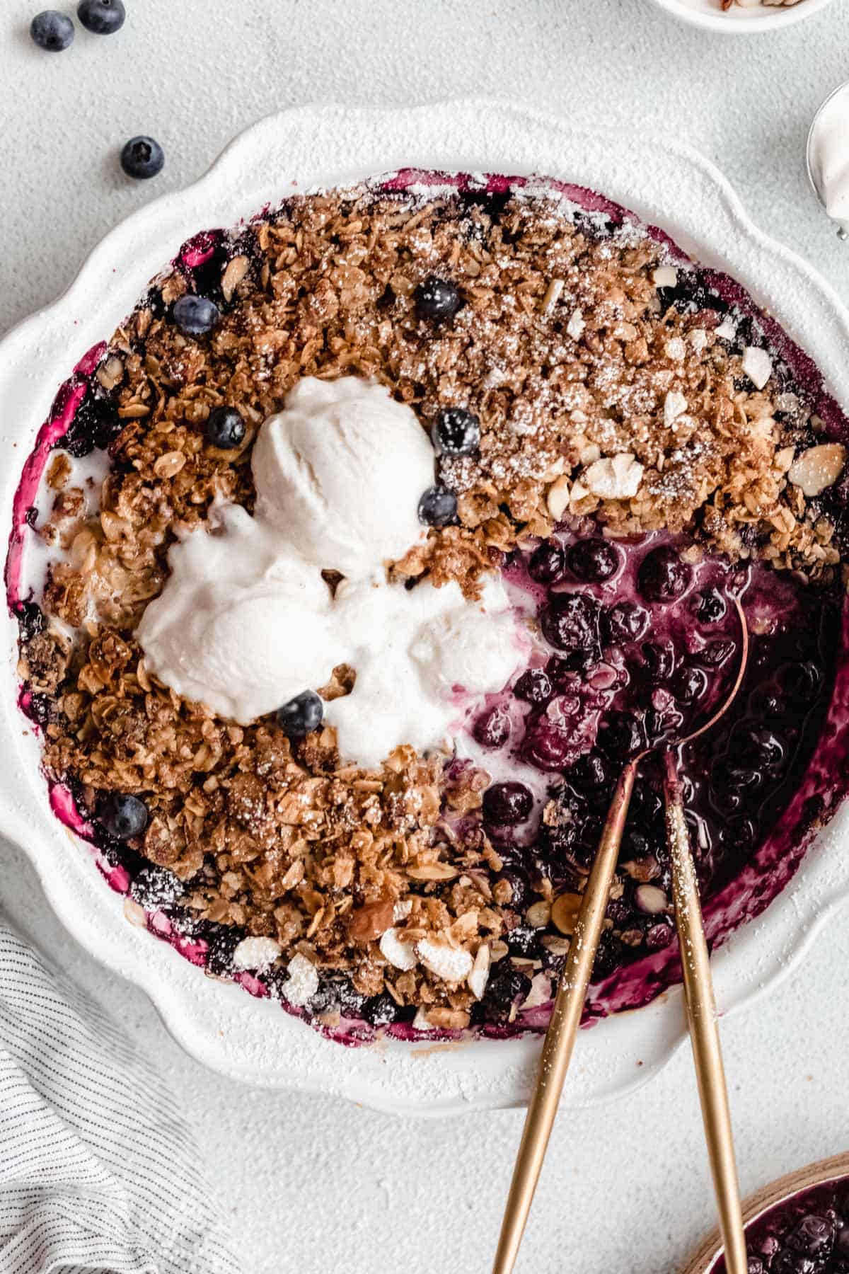 gluten free blueberry crisp in a pan with ice cream