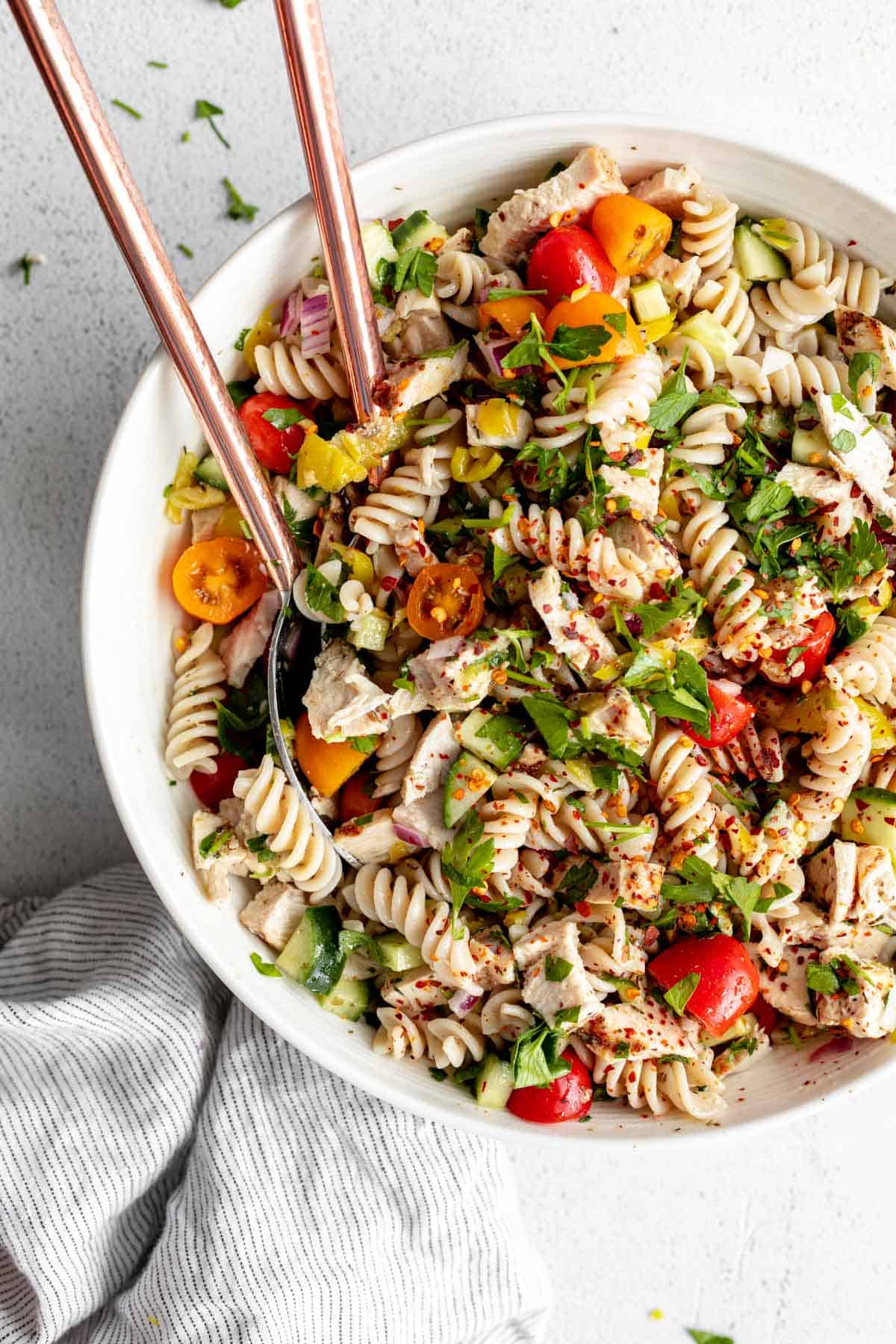 gluten free pasta salad in a bowl with spoons on the side