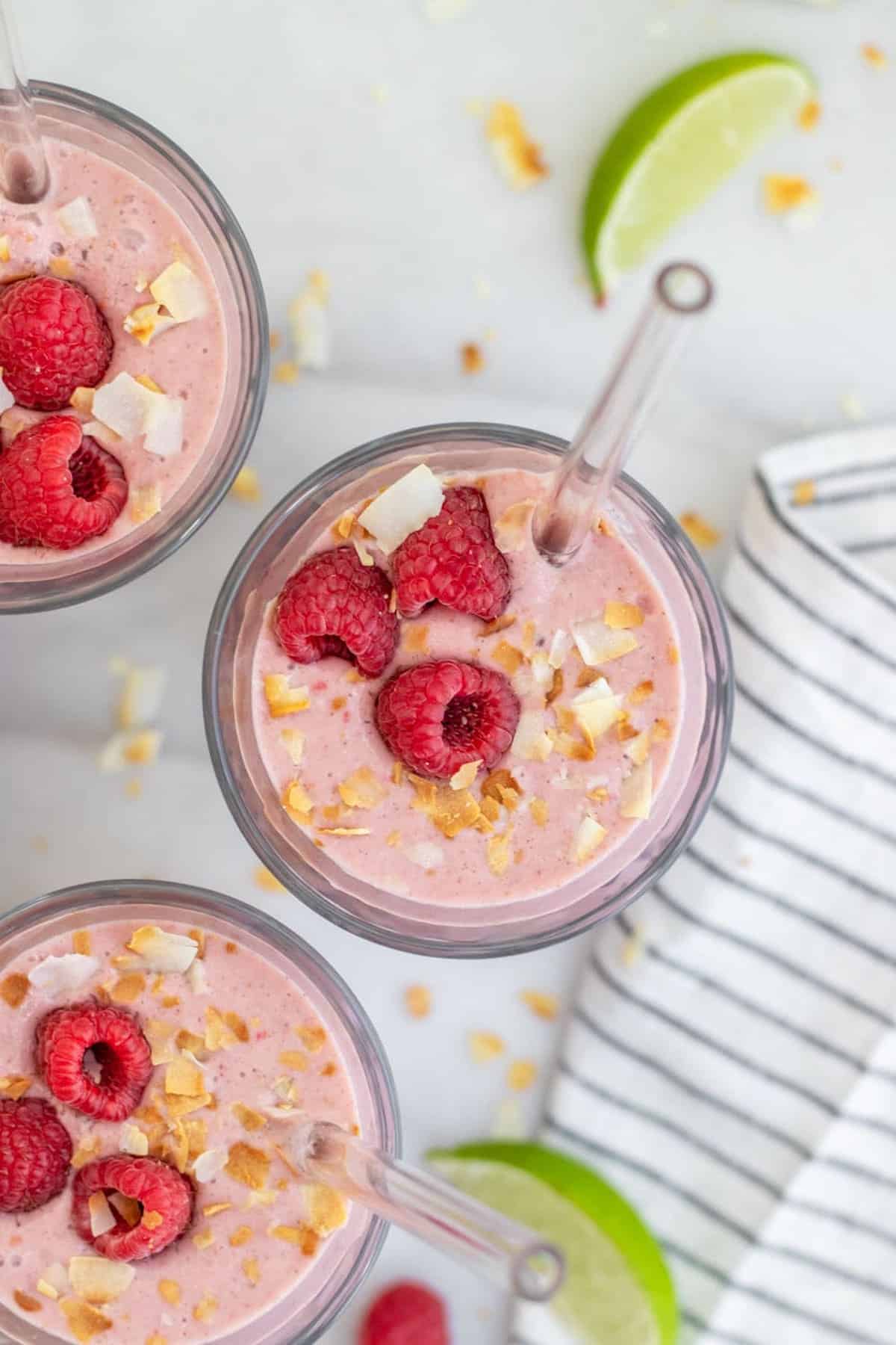 Overhead shot of raspberry smoothie recipe with fruit on top.