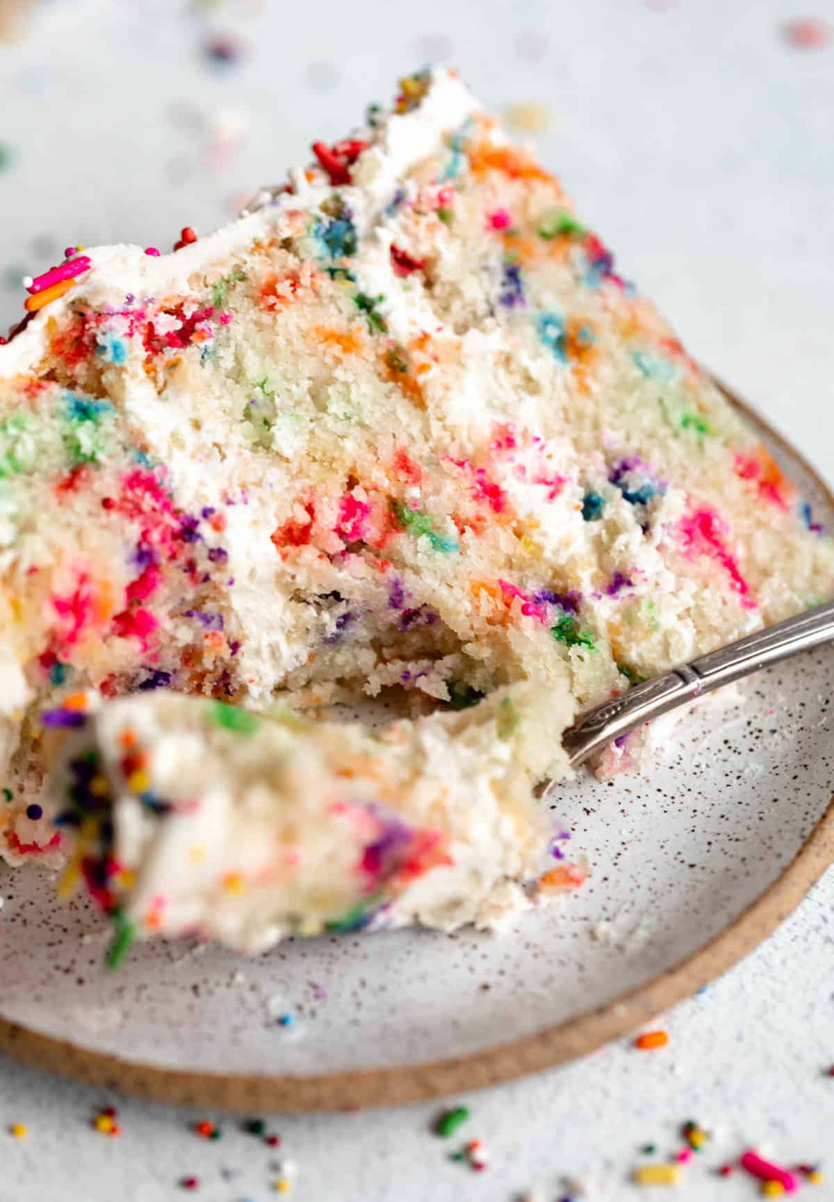 vegan gluten free vanilla cake with sprinkles on a plate