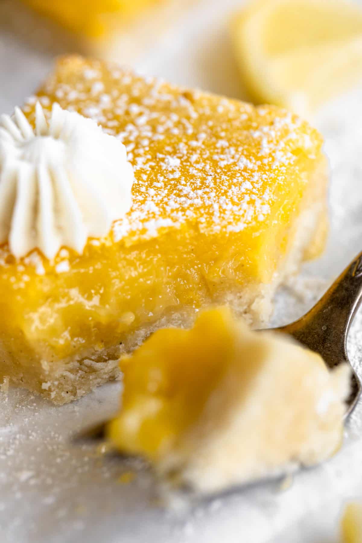 up close of gluten free lemon bars with a bite taken out