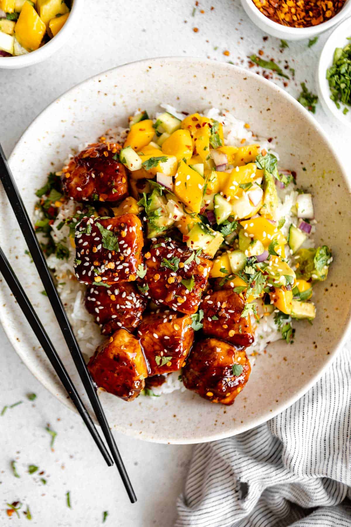 honey glazed salmon bites in a bowl with rice and mango salsa