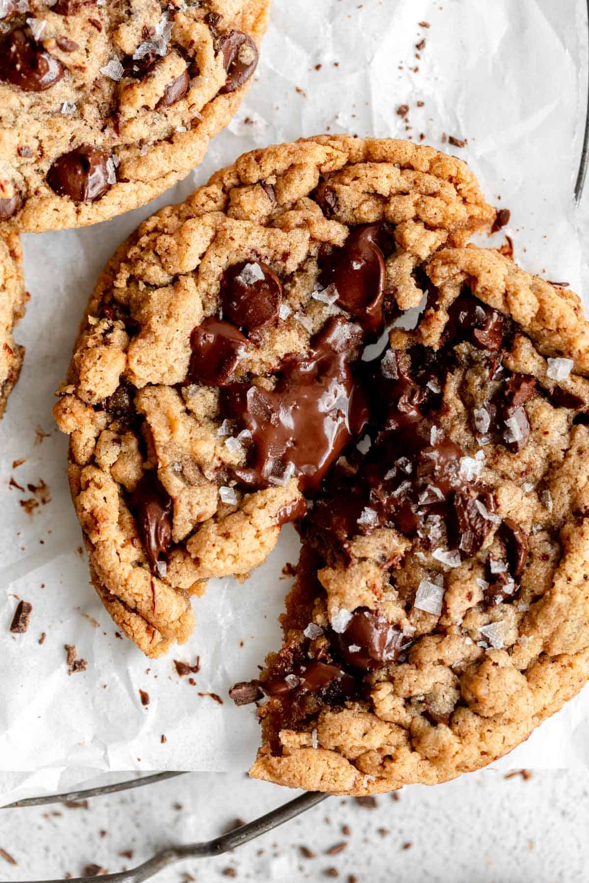 vegan tahini chocolate chip cookie ripped in half with melted chocolate
