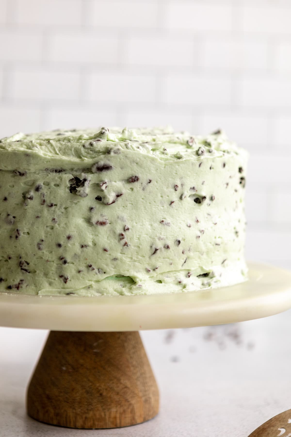 cake on a cake stand with the mint chocolate frosting