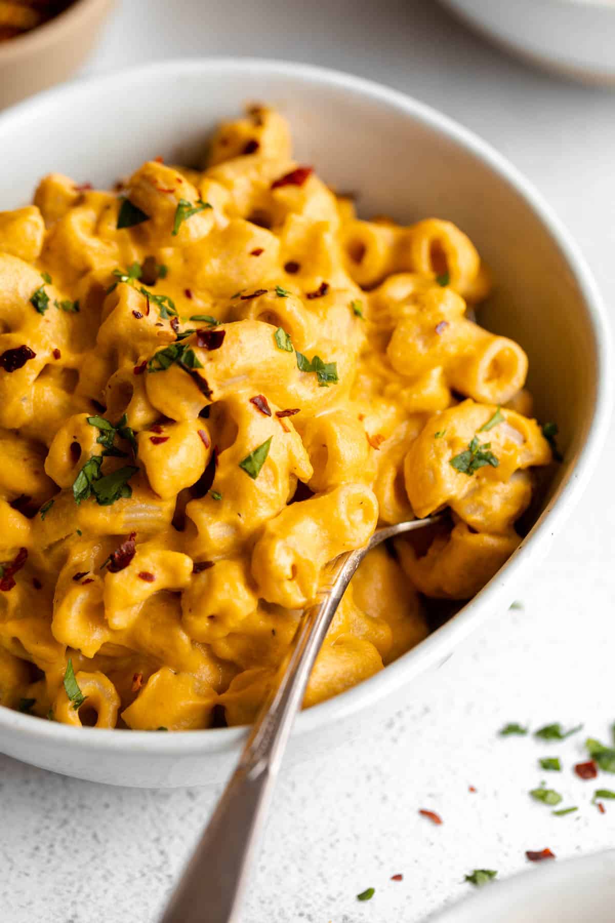 vegan sweet potato mac and cheese in a bowl with a fork