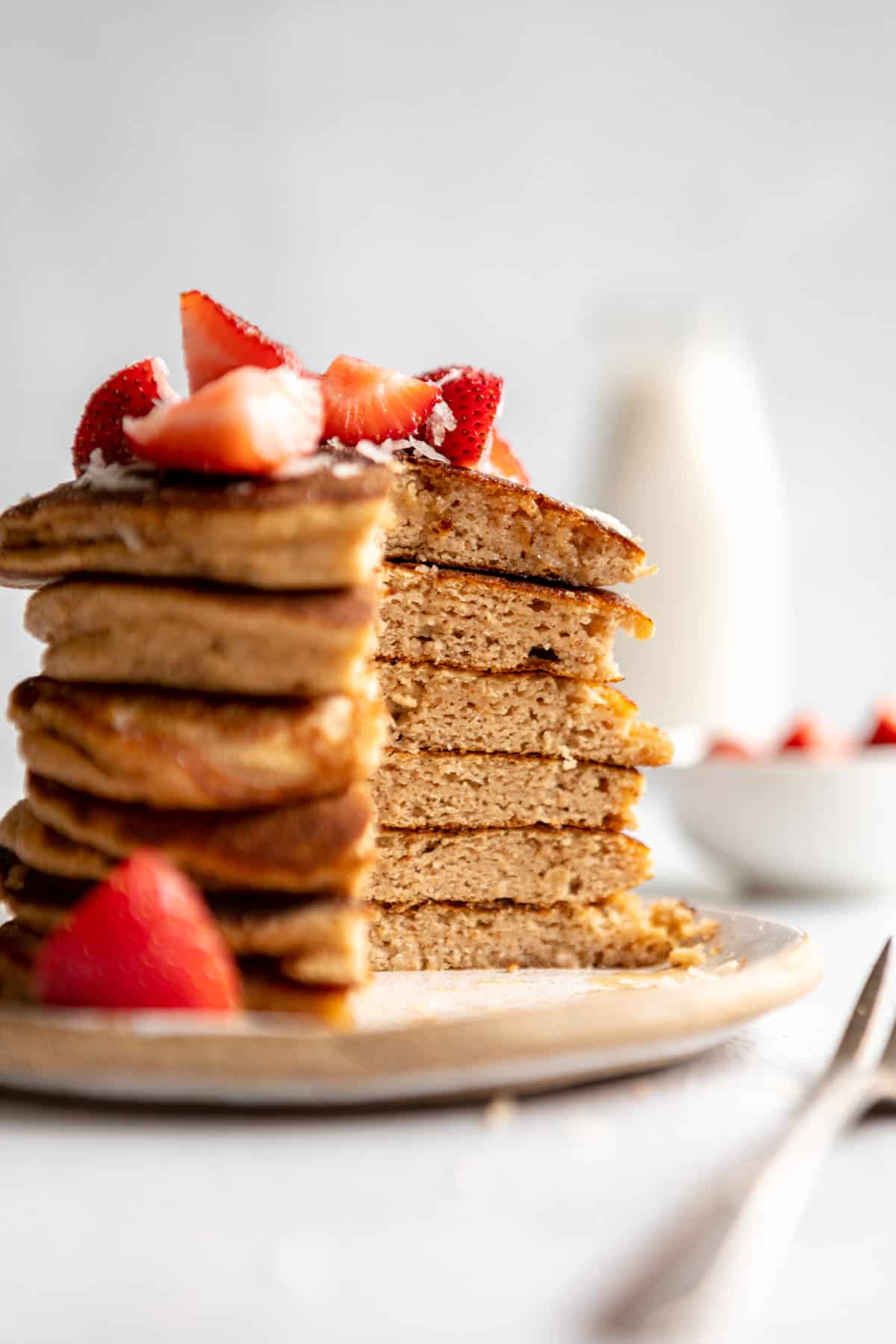 coconut flour pancakes with strawberries and maple syrup on a plate