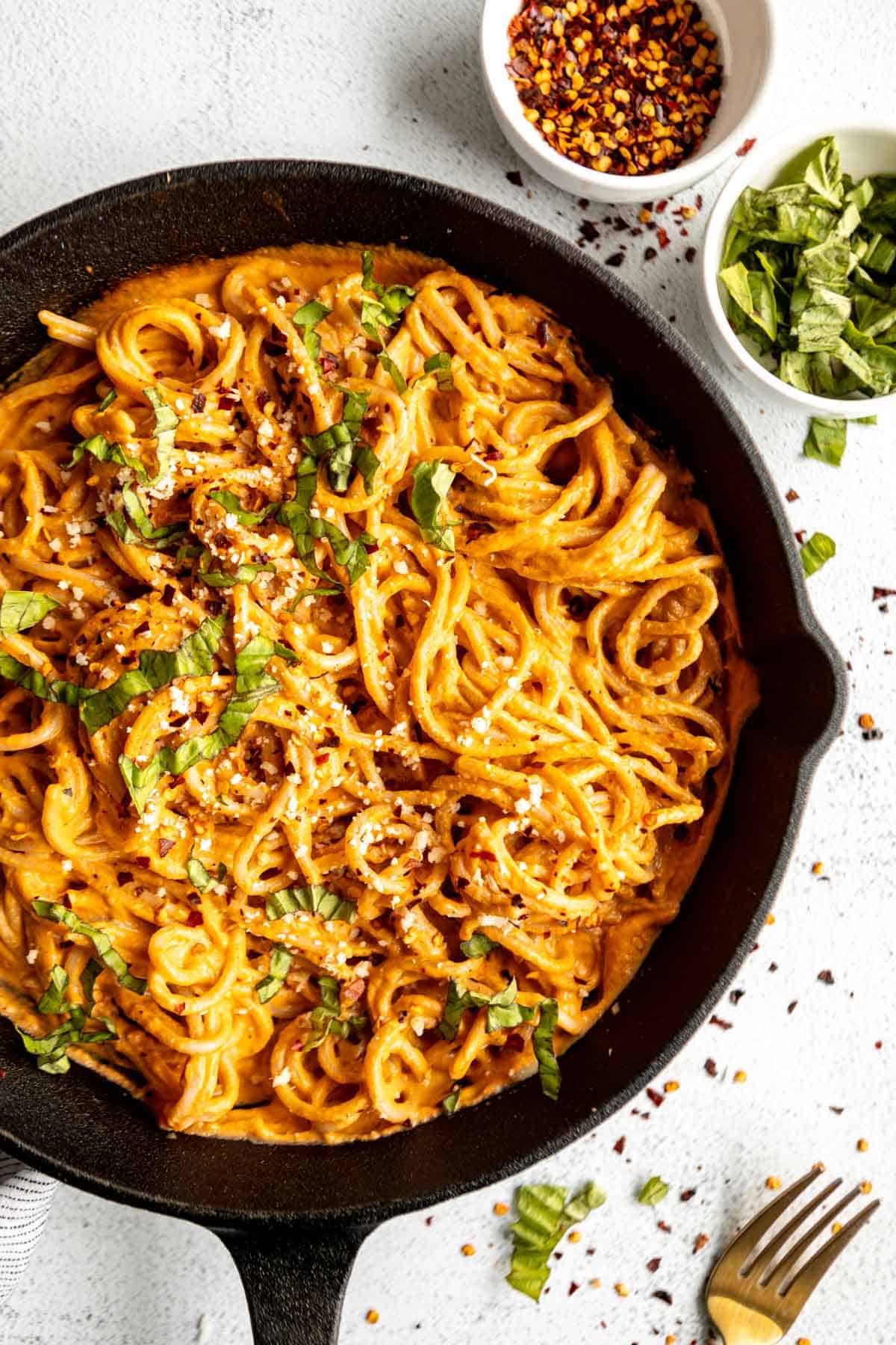 roasted red pepper pasta in a skillet with basil