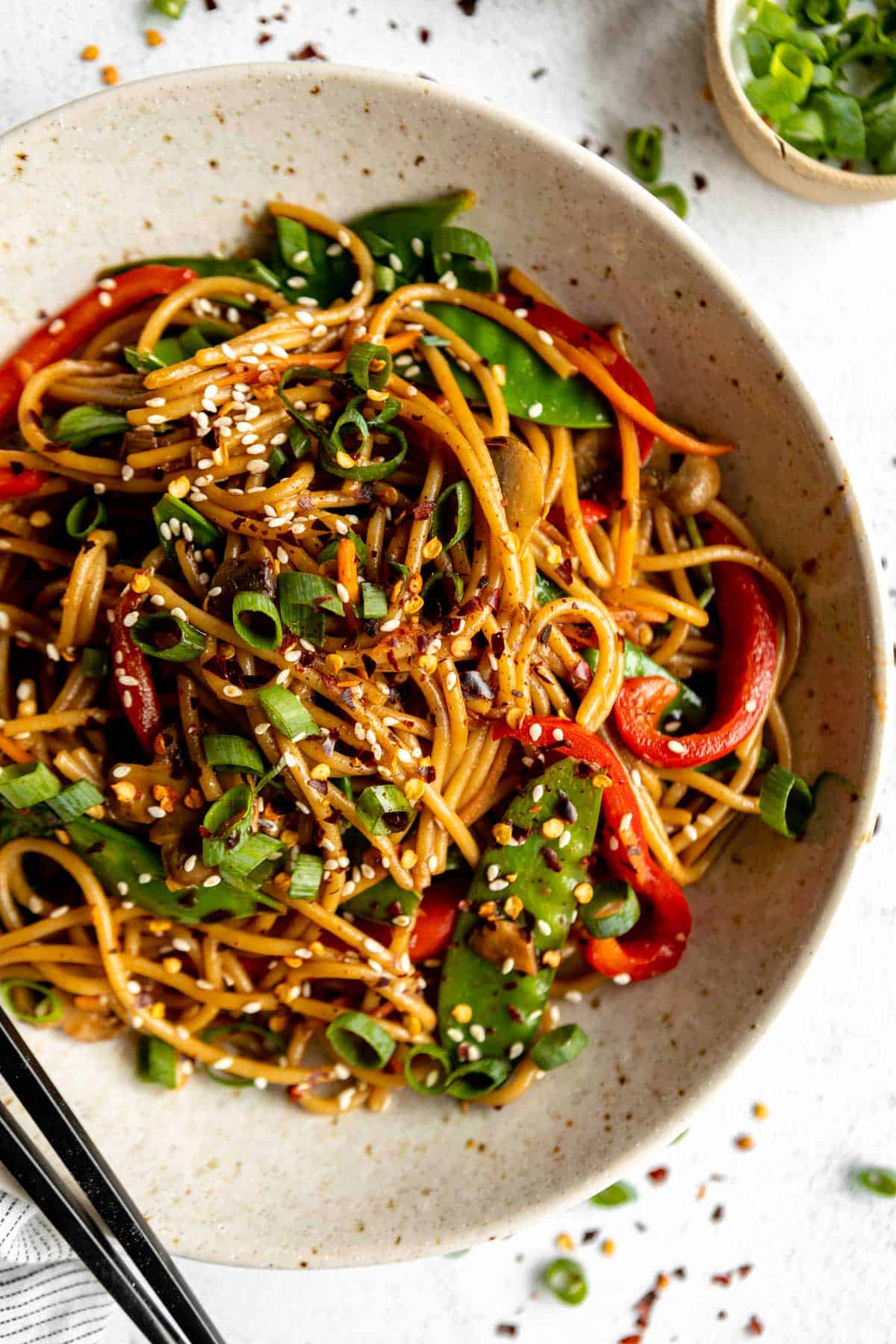 vegan vegetable lo mein in a bowl with sesame seeds on top